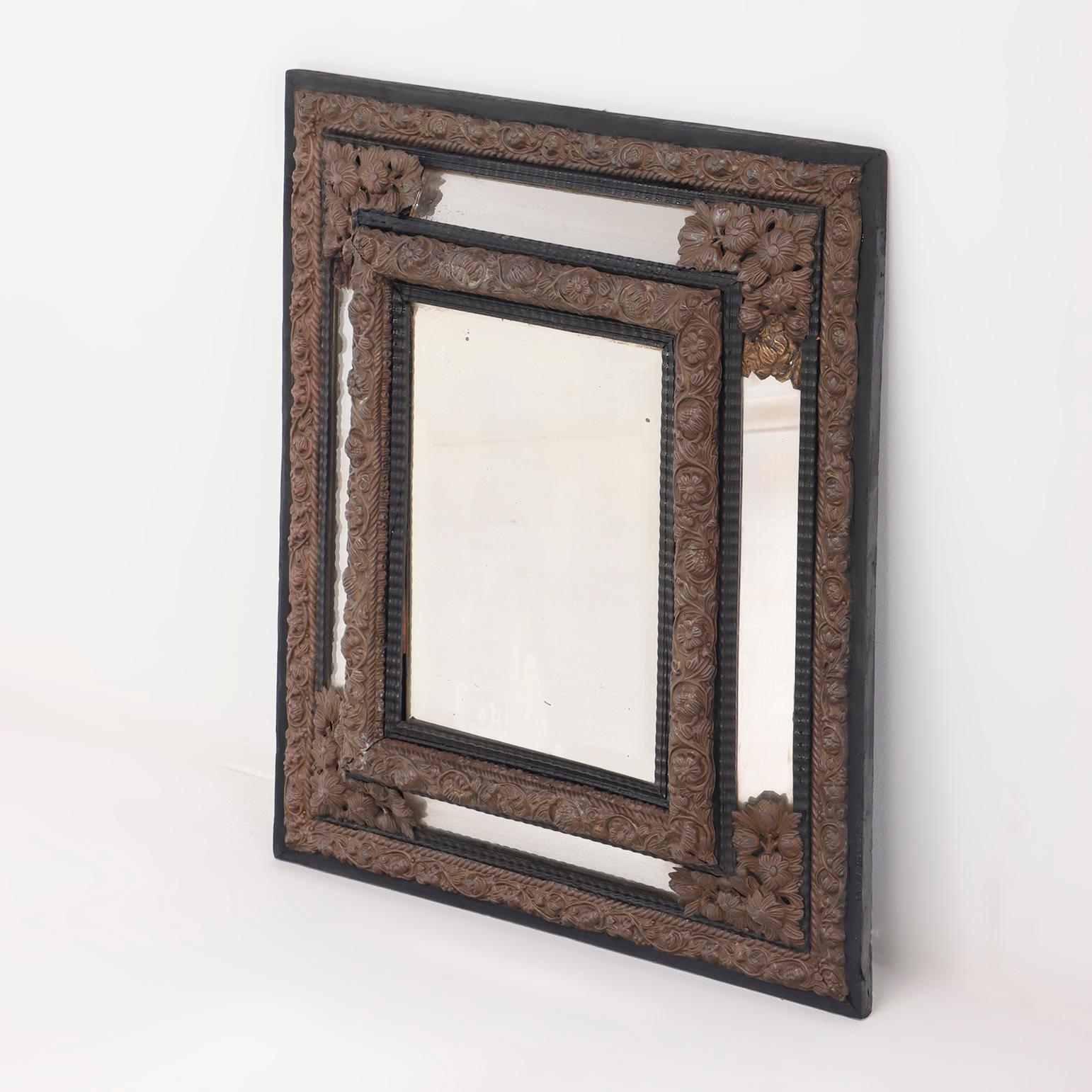 Small nineteenth century Continental brass and wood repousse mirror having ripple form mouldings.