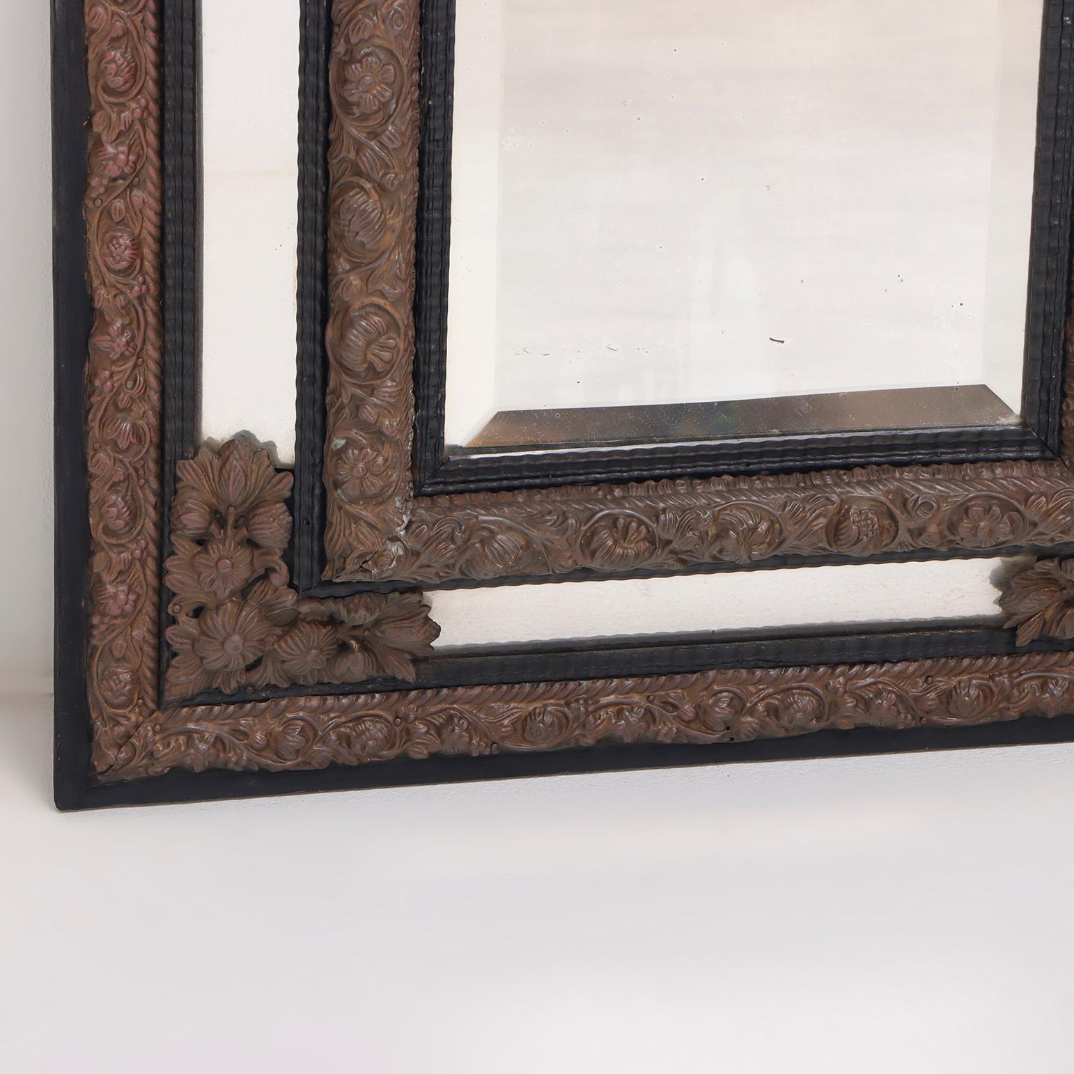 Continental brass and wood repousse mirror having ripple form mouldings. In Good Condition For Sale In Philadelphia, PA