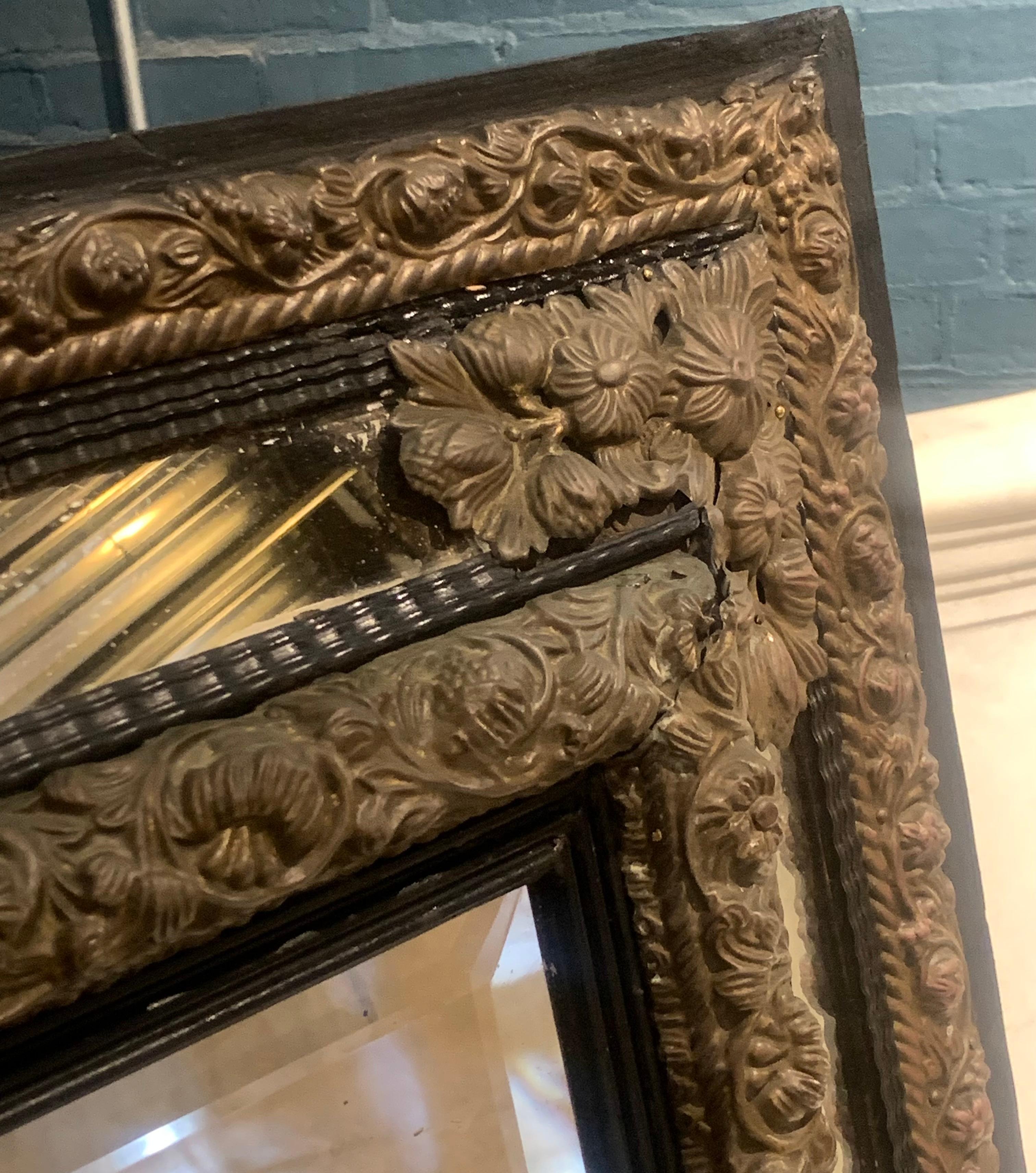 Continental brass and wood repousse mirror having ripple form mouldings. In Good Condition In Philadelphia, PA