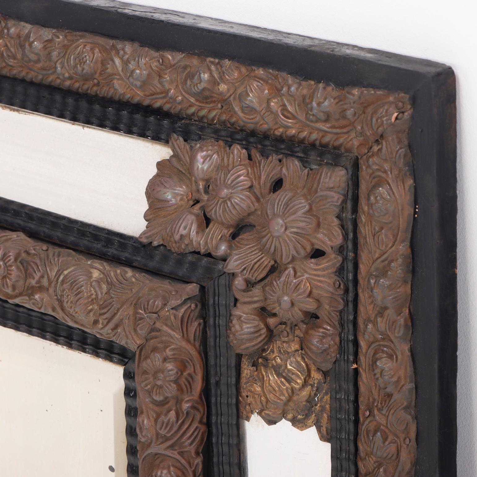 XIXe siècle Miroir repoussé continental en laiton et bois avec moulures de forme ondulée. en vente