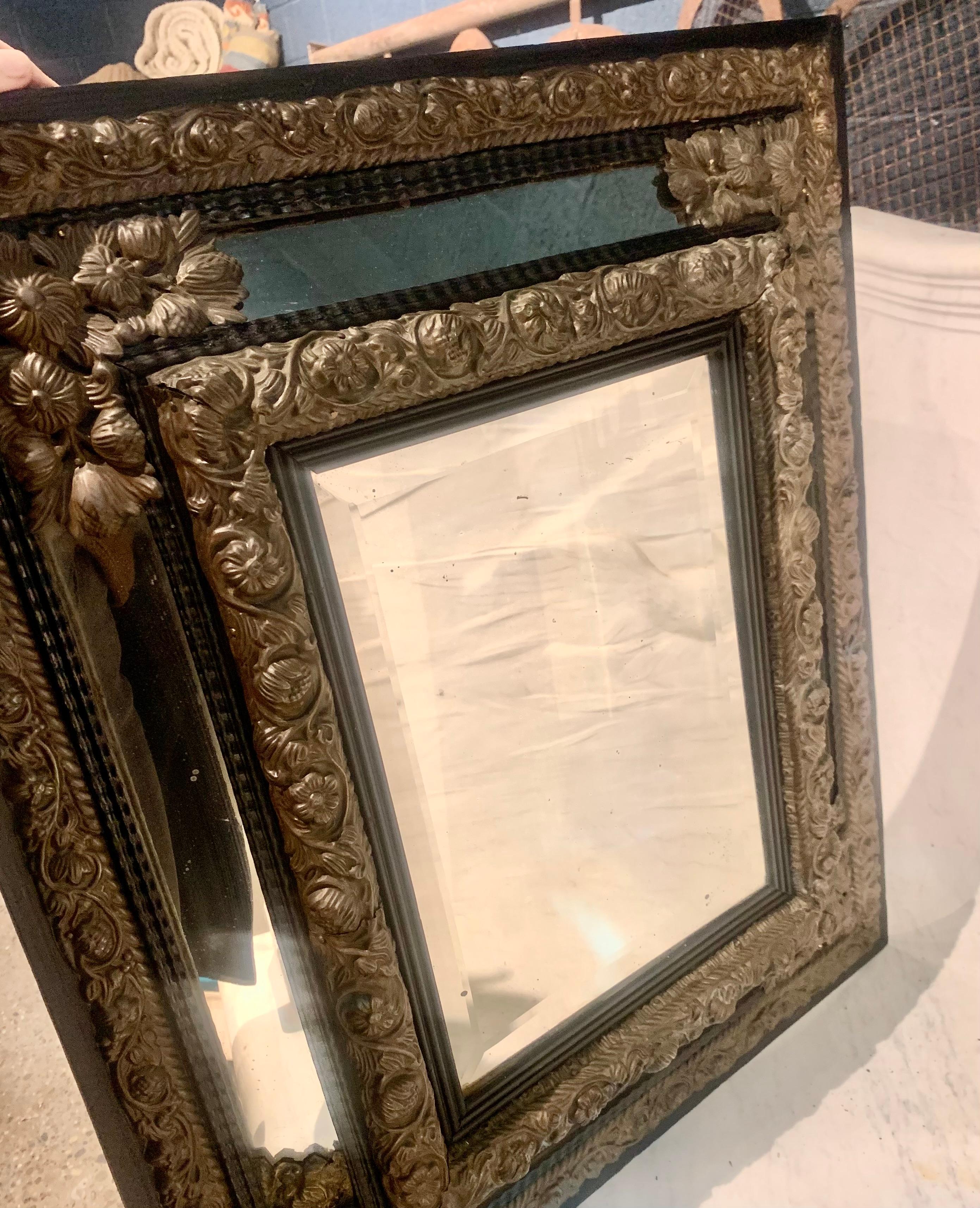 19th Century Continental brass and wood repousse mirror having ripple form mouldings.