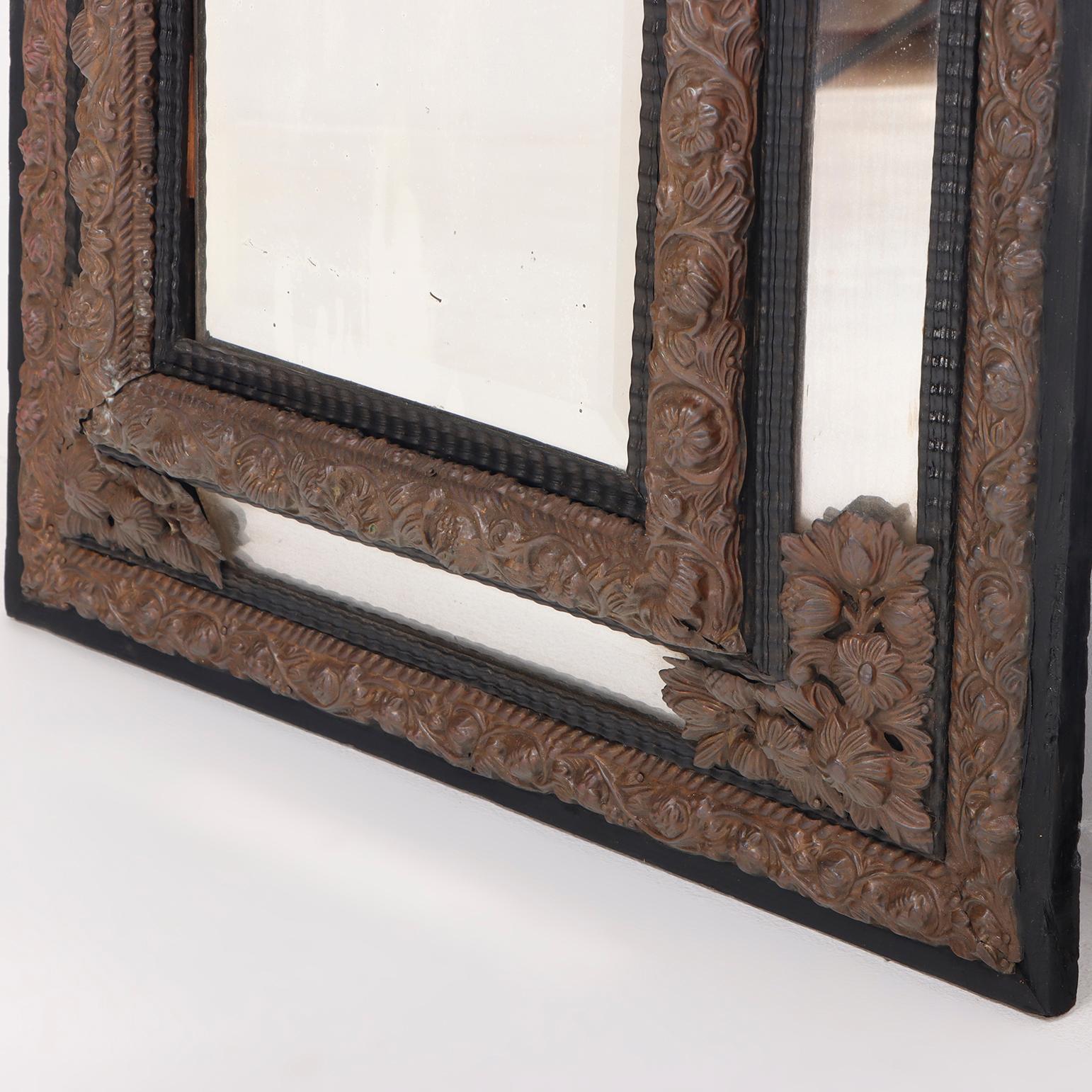 Laiton Miroir repoussé continental en laiton et bois avec moulures de forme ondulée. en vente