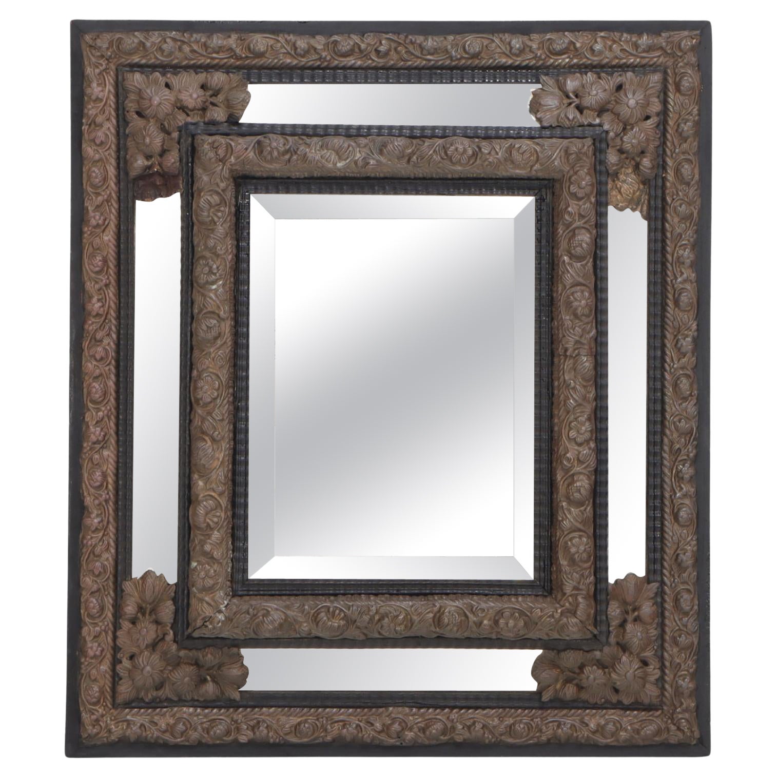 Continental brass and wood repousse mirror having ripple form mouldings.