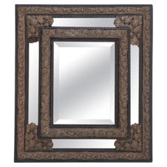 Antique Continental brass and wood repousse mirror having ripple form mouldings.