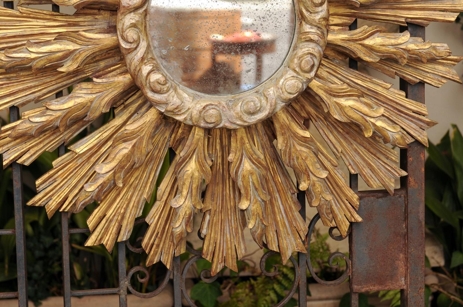 20th Century Continental Carved Giltwood Sunburst Mirror with Layered Rays and Cloudy Motifs