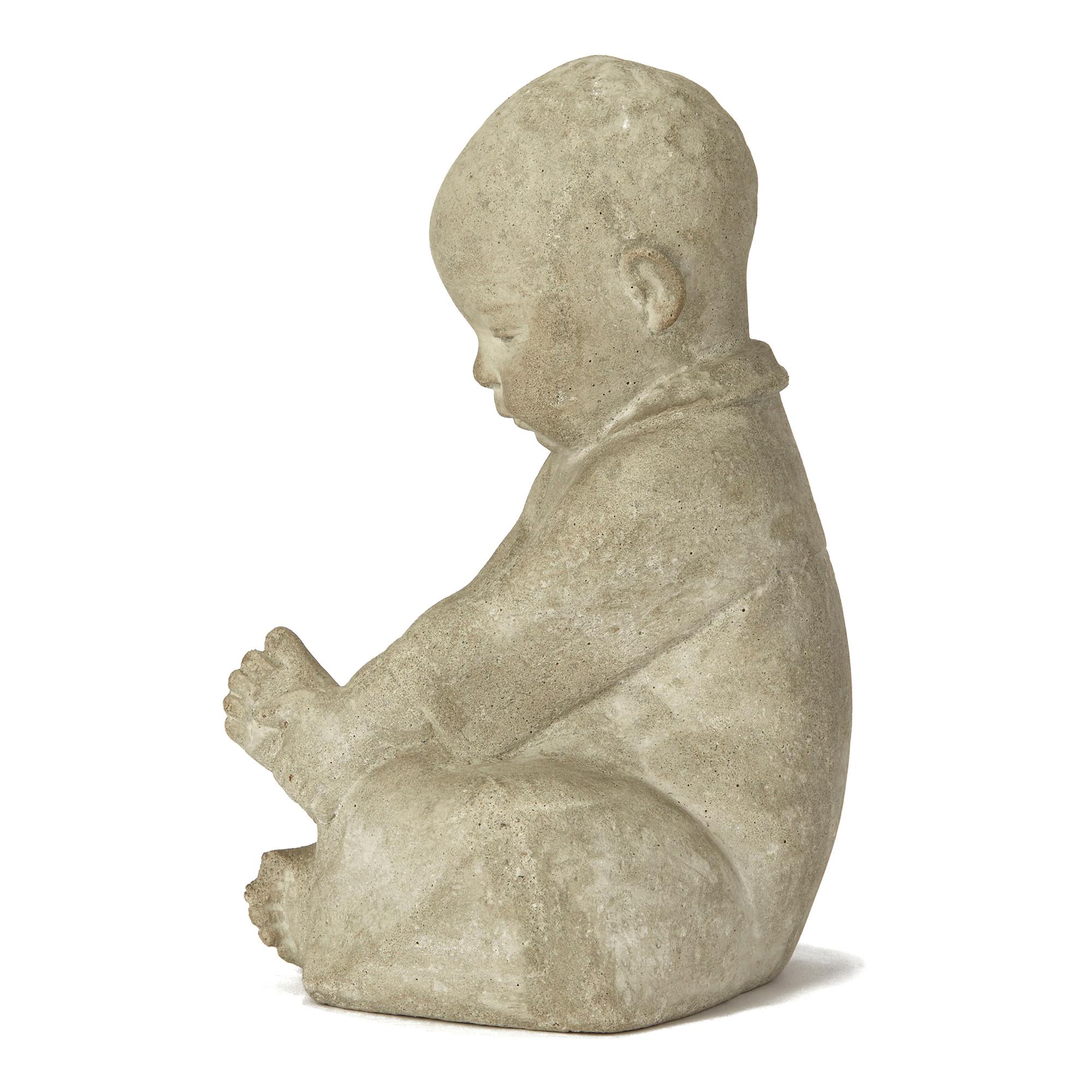 An exceptional charming continental, possibly Scandinavian, carved stone figure of a young seated infant holding his left foot. The right leg and lower body is carved into the base with the toes of the right foot emerging to the front and the infant