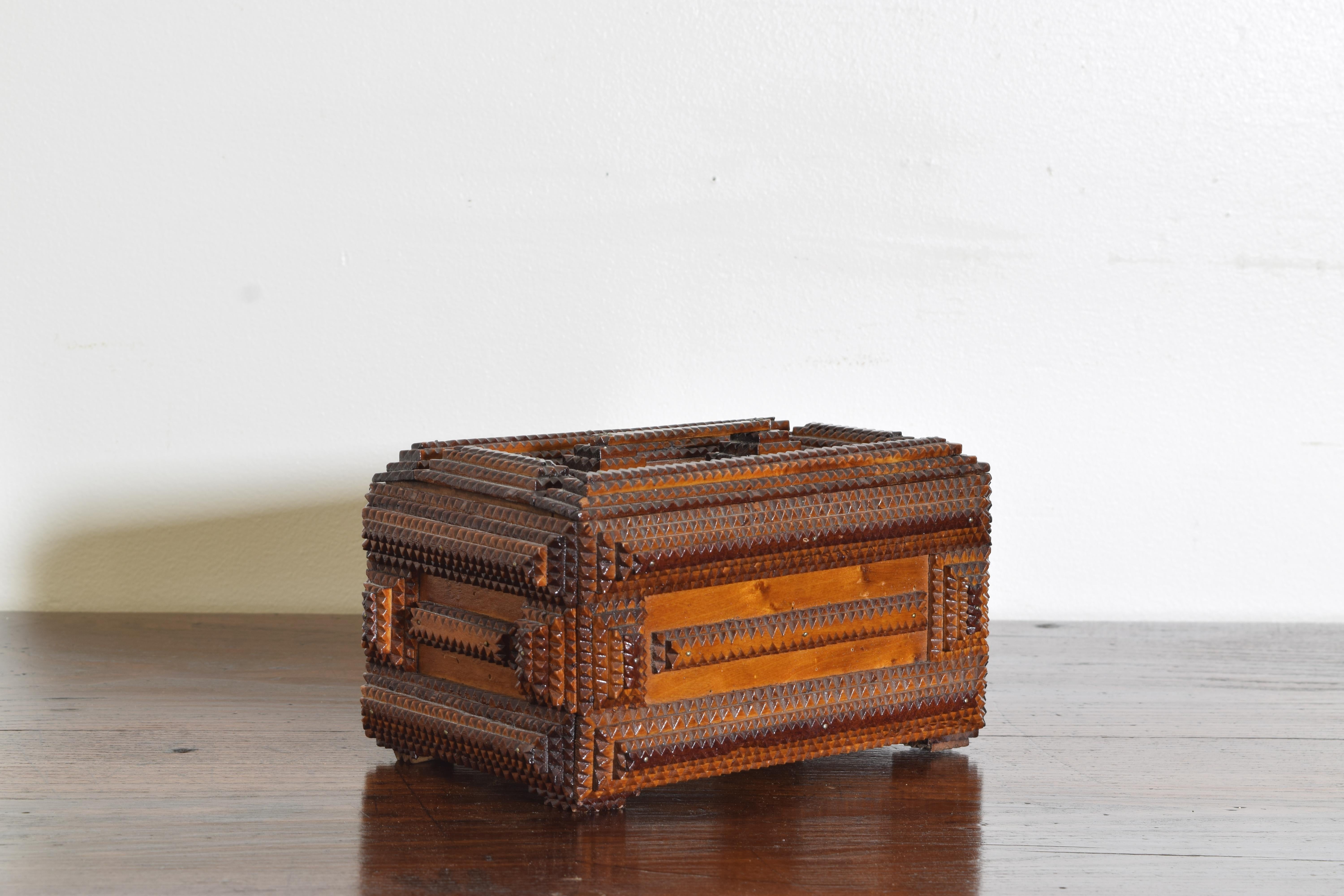 Rectangular box adorned with panels of geometric carvings popular in the early 20th century and known as Tramp Art