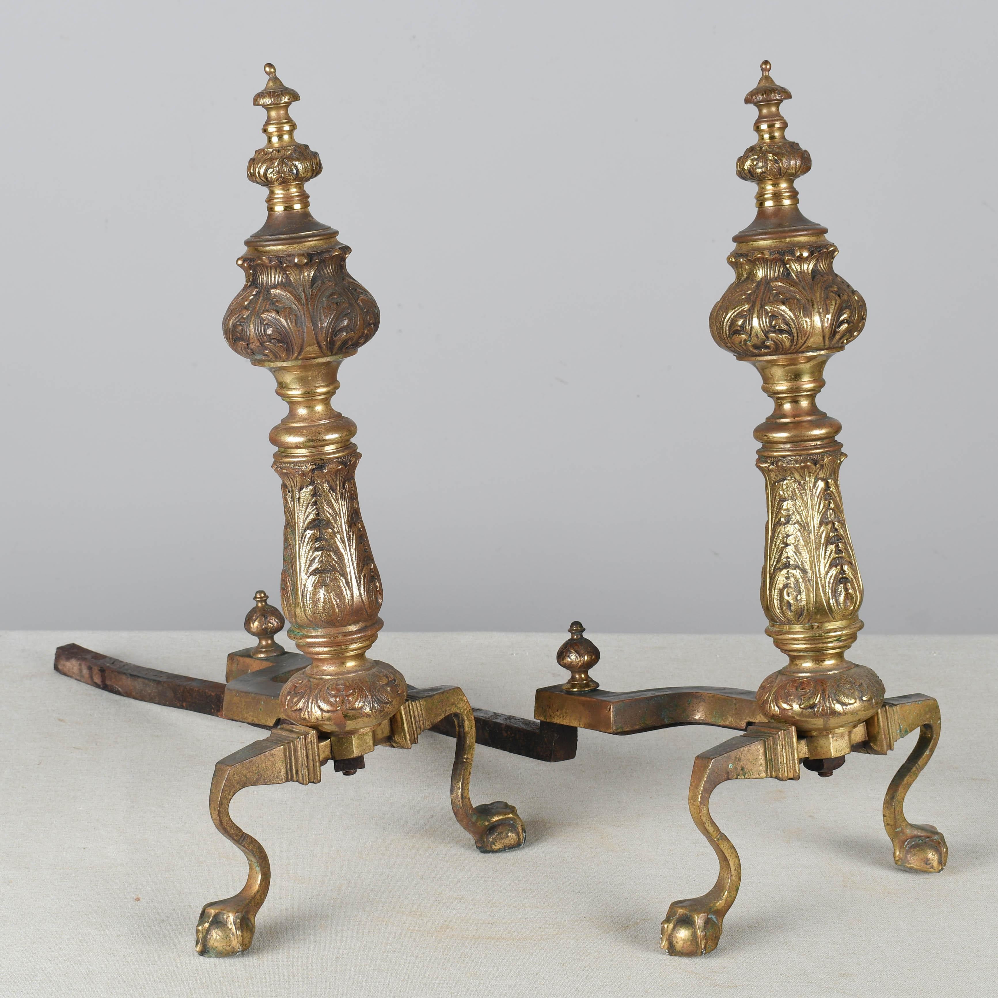 A pair of Continental cast bronze and iron chenets or andirons. Column form with foliate relief and ball and claw feet. Circa 1900-1920
Dimensions: 21