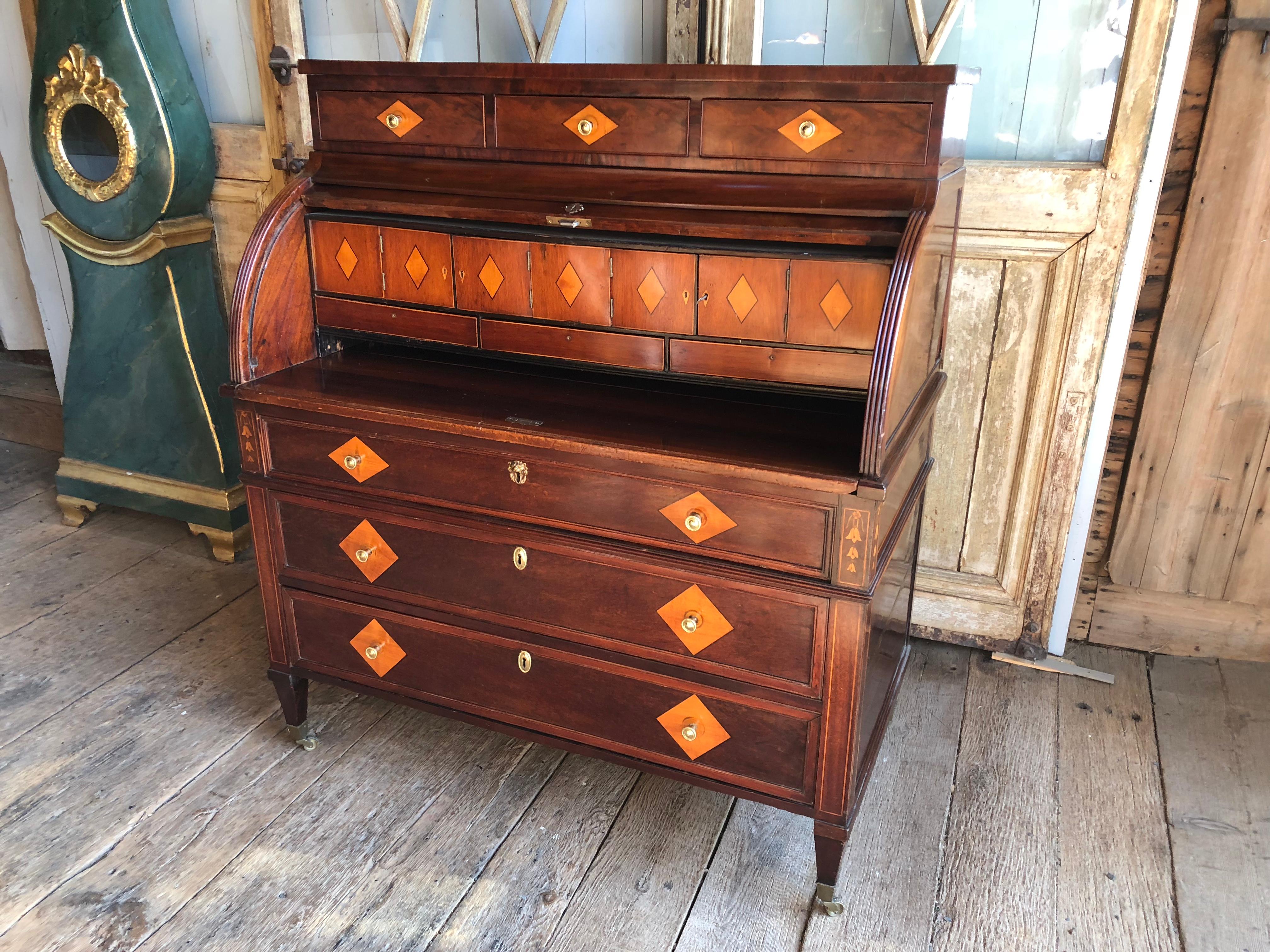 An early 19th century neoclassical cylinder desk in inlaid mahogany, with interior compartments and three lowernfull-legnth drawers, likely Dutch. From the personal collection of interior designer William Hodgins, Boston.