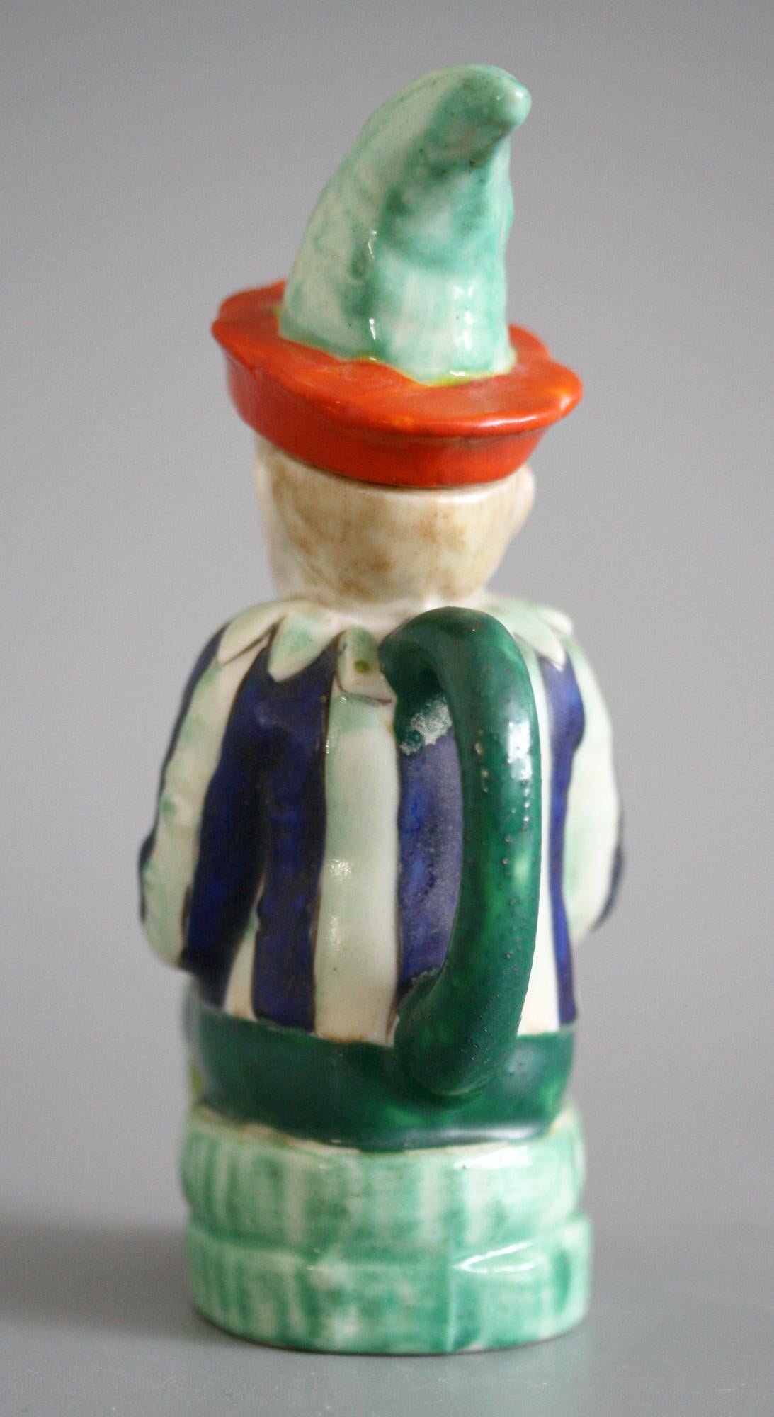 A delightful and very finely made antique continental, probably German, porcelain lidded jug modeled as Mr. Punch seated on a barrel and dating from circa 1900 or earlier. The figure has moulded detail and is nicely hand painted in naturalistic