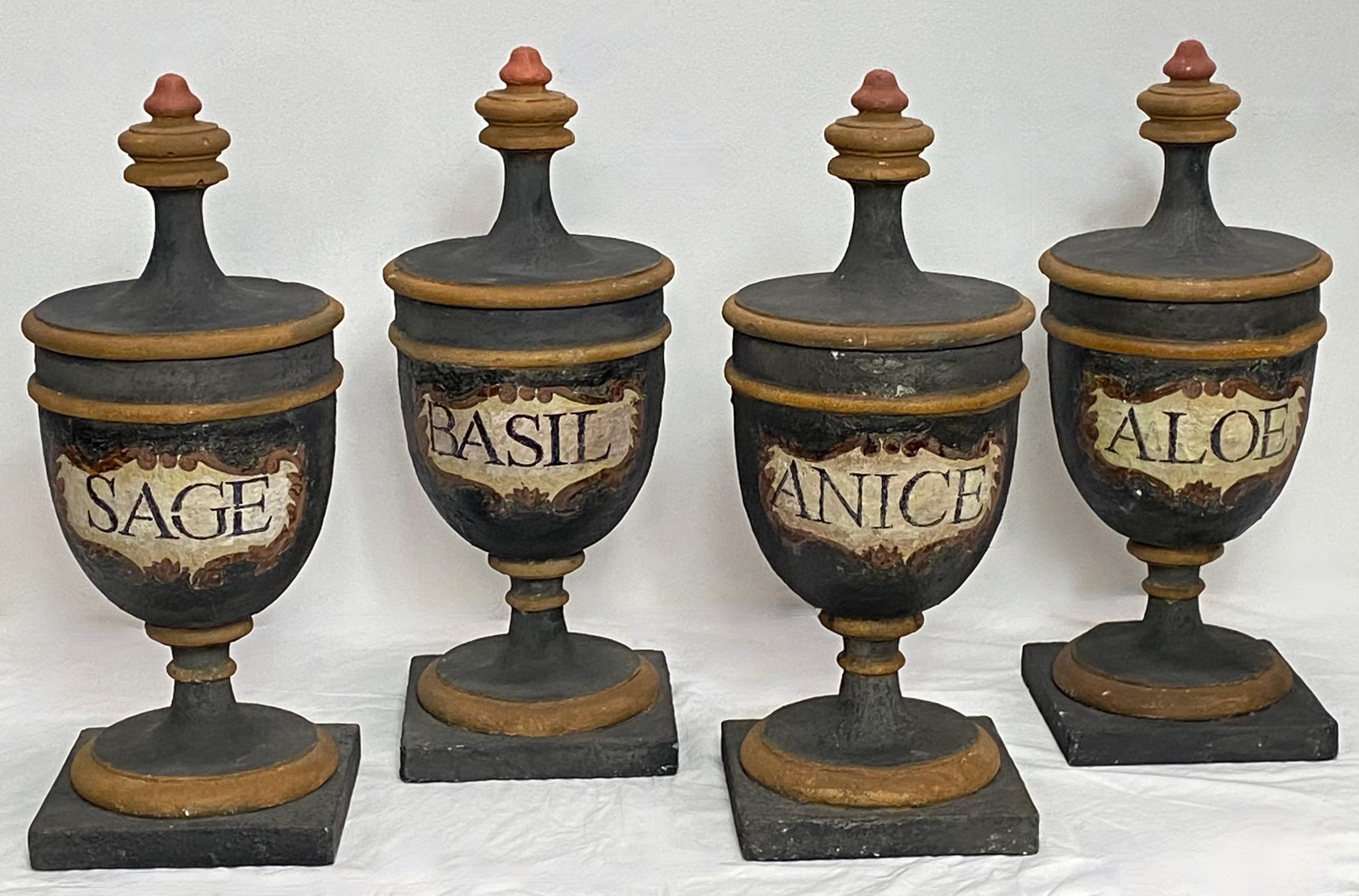 A wonderful set of large lidded urn shaped apothecary style spice jars, made from a low fired type of unglazed terracotta or earthenware. 
These jars have loads of character and presence with multiple layers of old paint and read