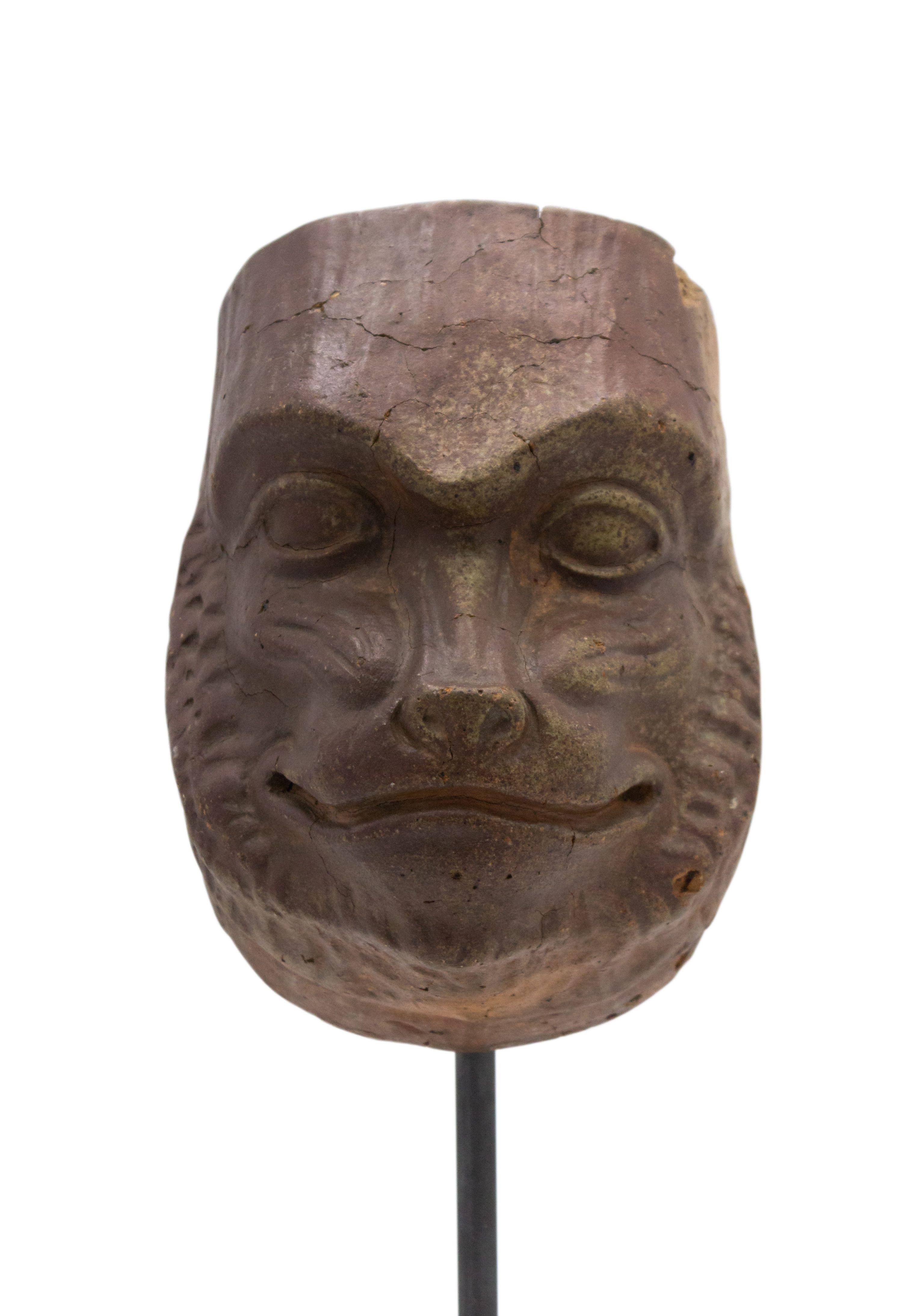 Continental German (late 19th Cent) sculpted terra-cotta master mask mold of a smiling baboon face displayed on a square black marble base stand (part of a collection).
 