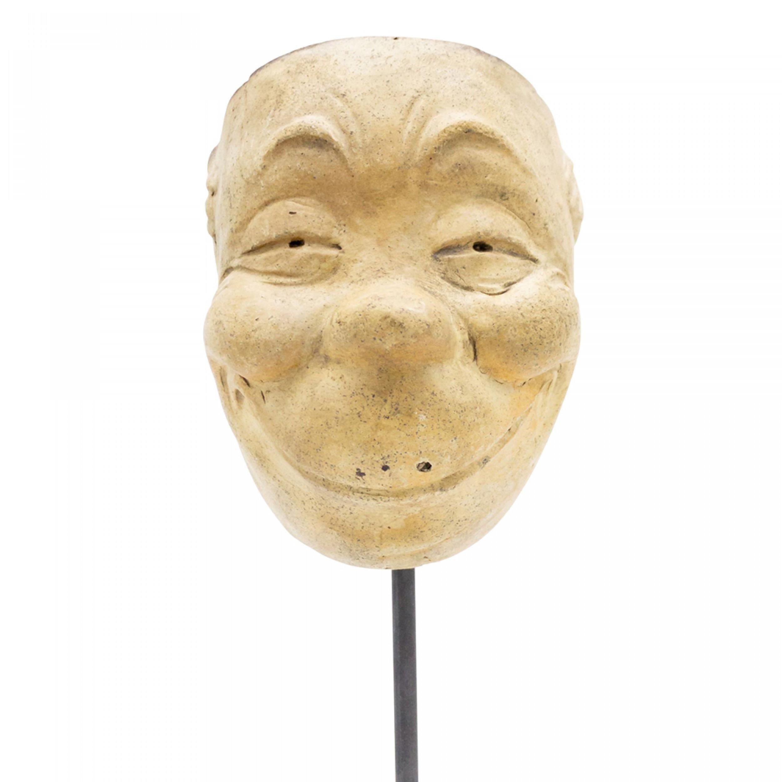 Máscara de terracota esculpida en Alemania continental (finales del siglo XIX) de un rostro sonriente de 