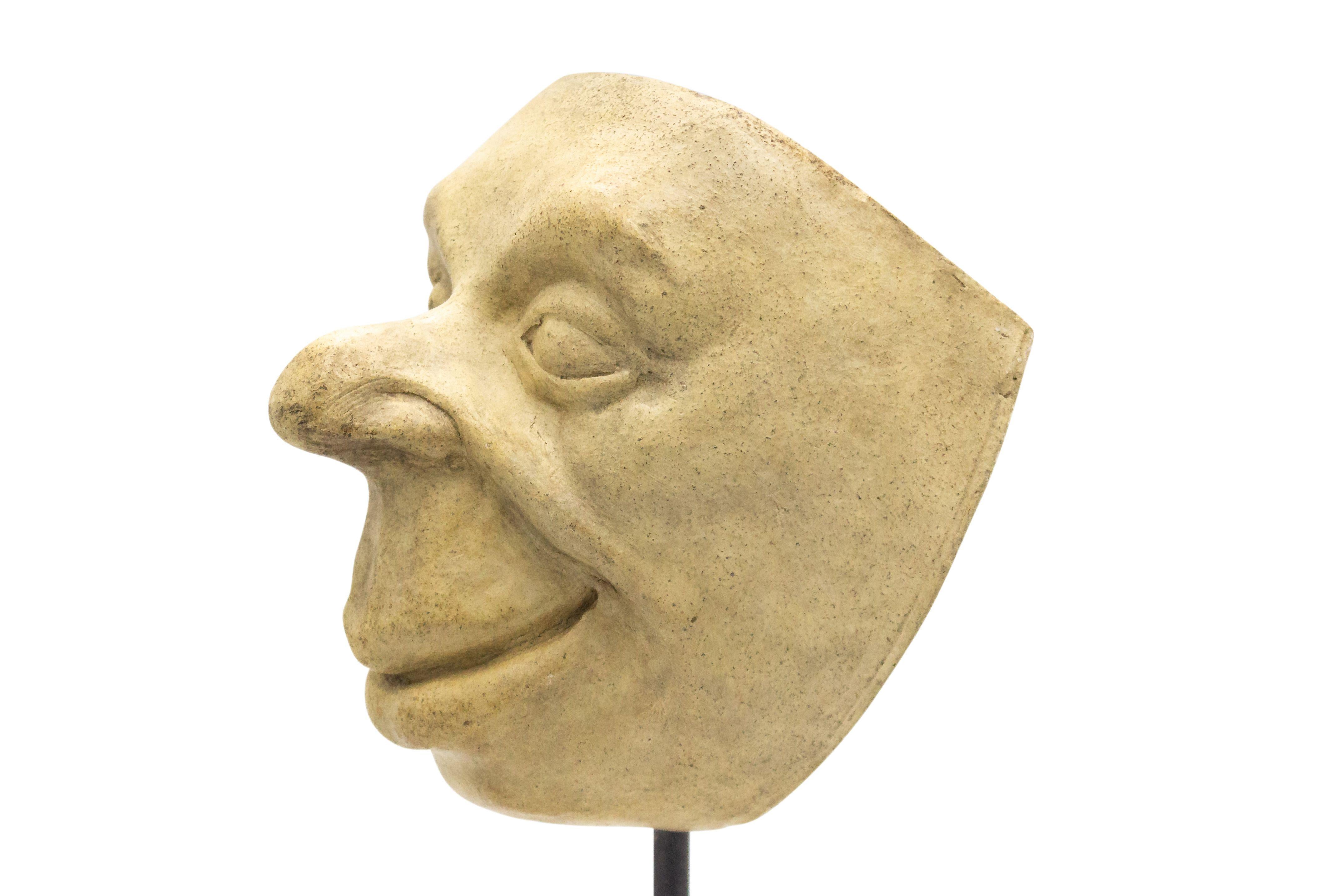 Continental German (late 19th Cent) sculpted terra-cotta master mask mold of a smiling grotesque face with a bulbous nose and lips displayed on a square black marble base stand (part of a 39 piece collection).
 