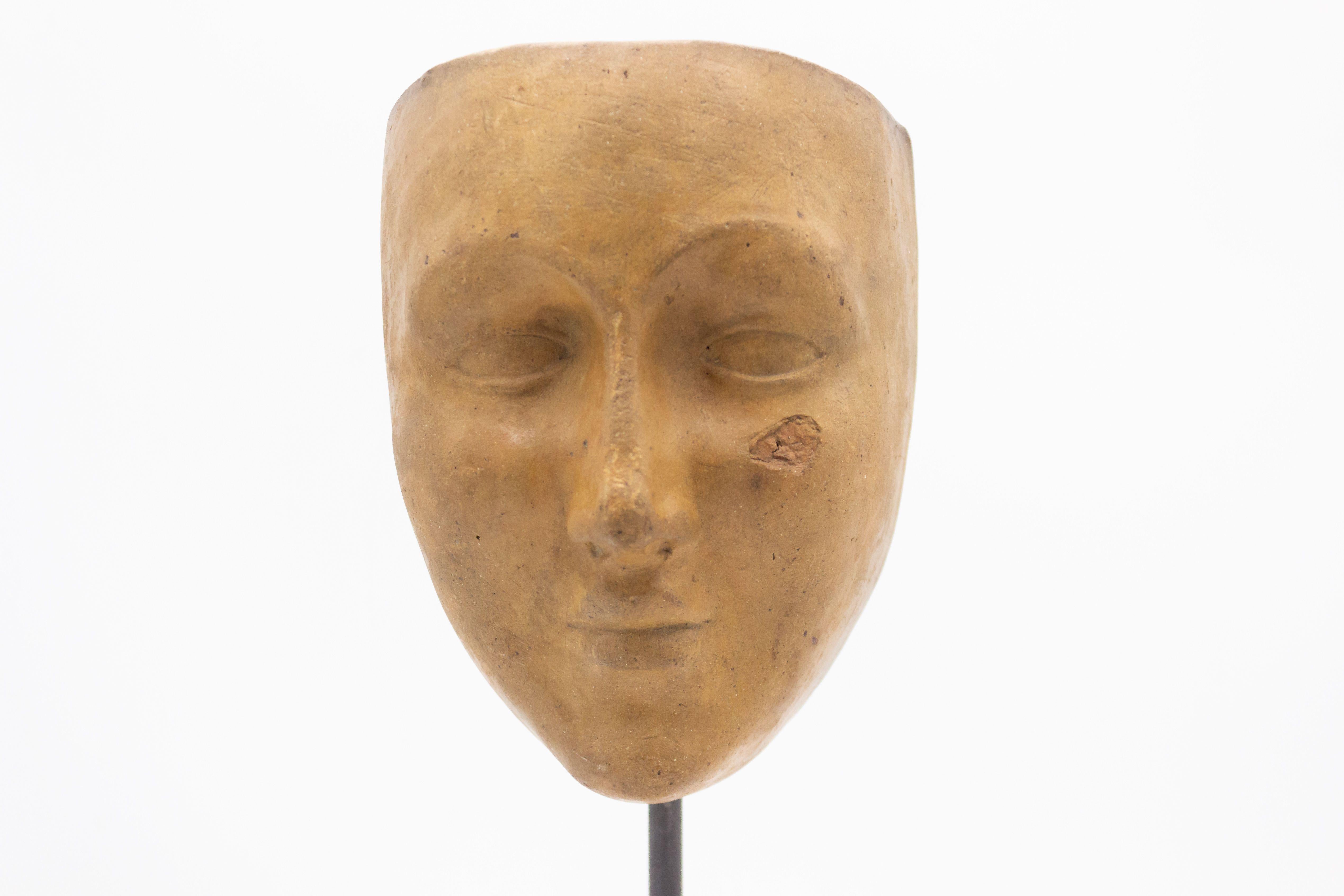 Continental German (late 19th Cent) sculpted terra-cotta master mask mold bust of a serene face displayed on a square black marble base Stand (part of a 39 piece collection).
 