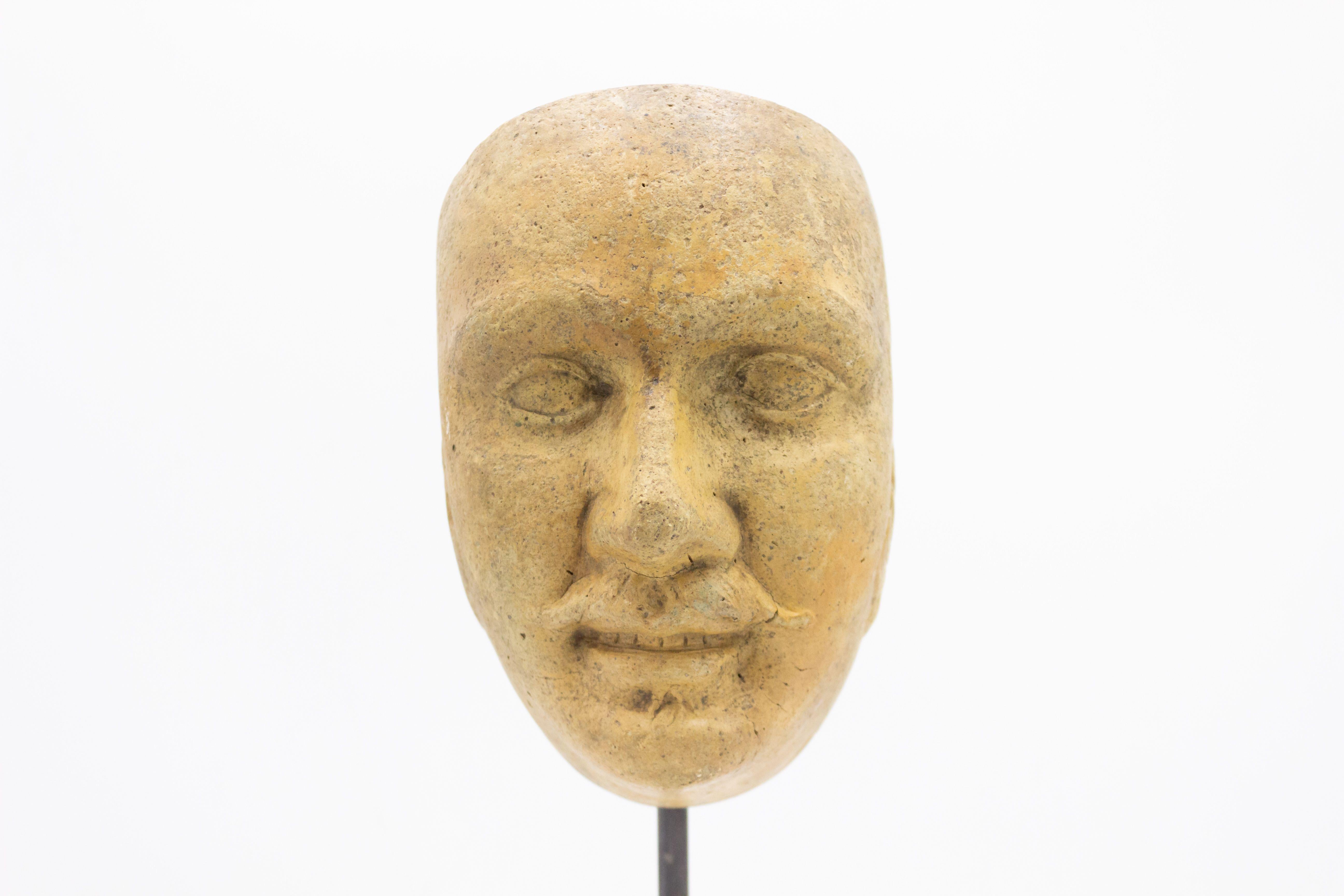 Kontinentaldeutsche (spätes 19. Jh.) Terrakotta-Maskenformbüste eines grinsenden Mannes mit Schnurrbart und Koteletten auf einem quadratischen schwarzen Marmorsockel (Teil einer 39-teiligen Sammlung).
 