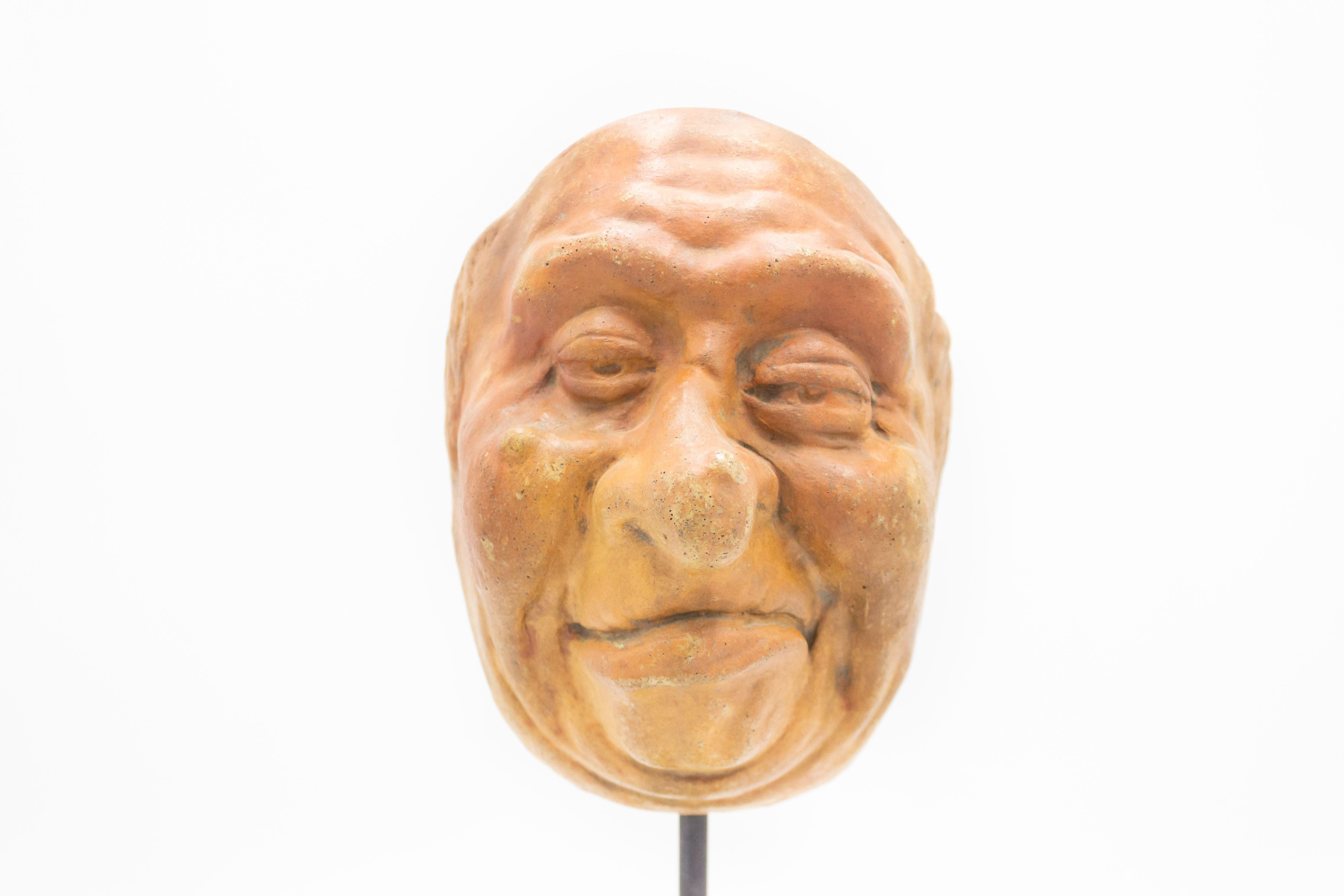 Continental German (late 19th Cent) sculpted terra-cotta master mask mold of a smiling Grotesque face with a wart on nose displayed on a square black marble base stand (part of a 39 piece collection).
 