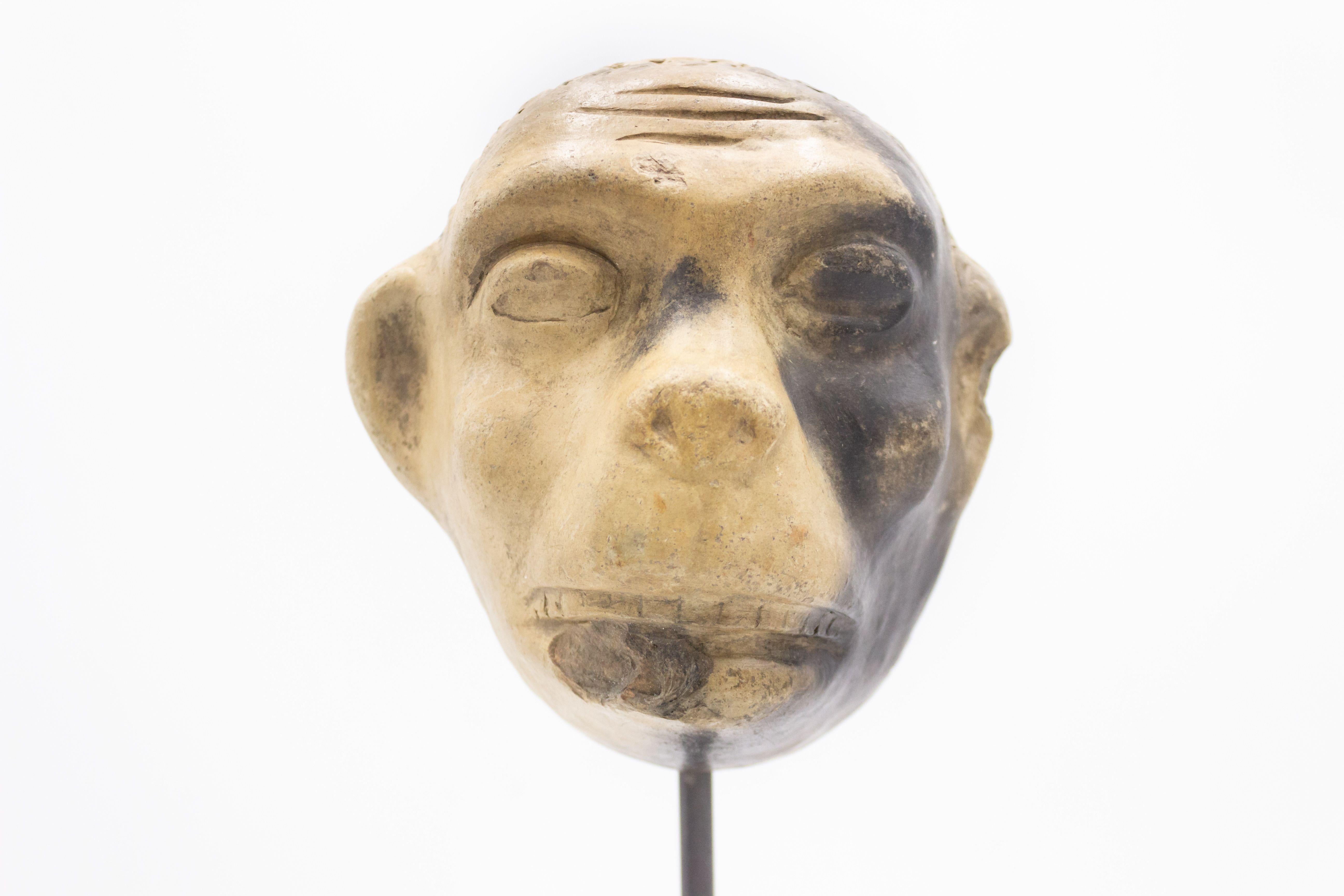 Kontinentaldeutsche (spätes 19. Jh.) Terrakotta-Maskenform eines Affengesichts, ausgestellt auf einem quadratischen schwarzen Marmorsockel (Teil einer Sammlung).
 