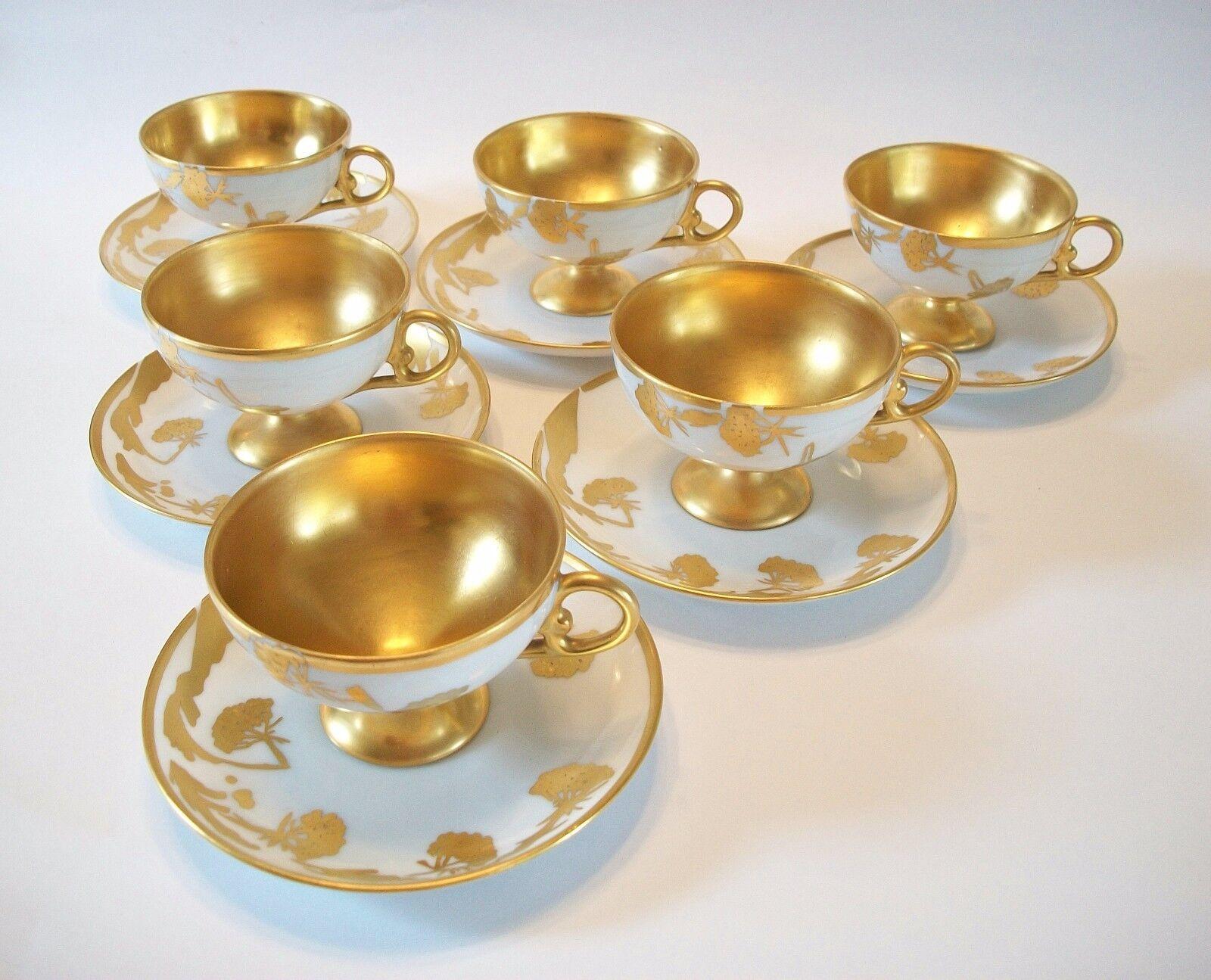 Finest quality hand painted gilt porcelain set of six cups and saucers - each piece with a stylized floral design and a gold wash to the interior of each cup along with gold rims - most pieces hand signed with 'J K' (likely the artist/decorator -