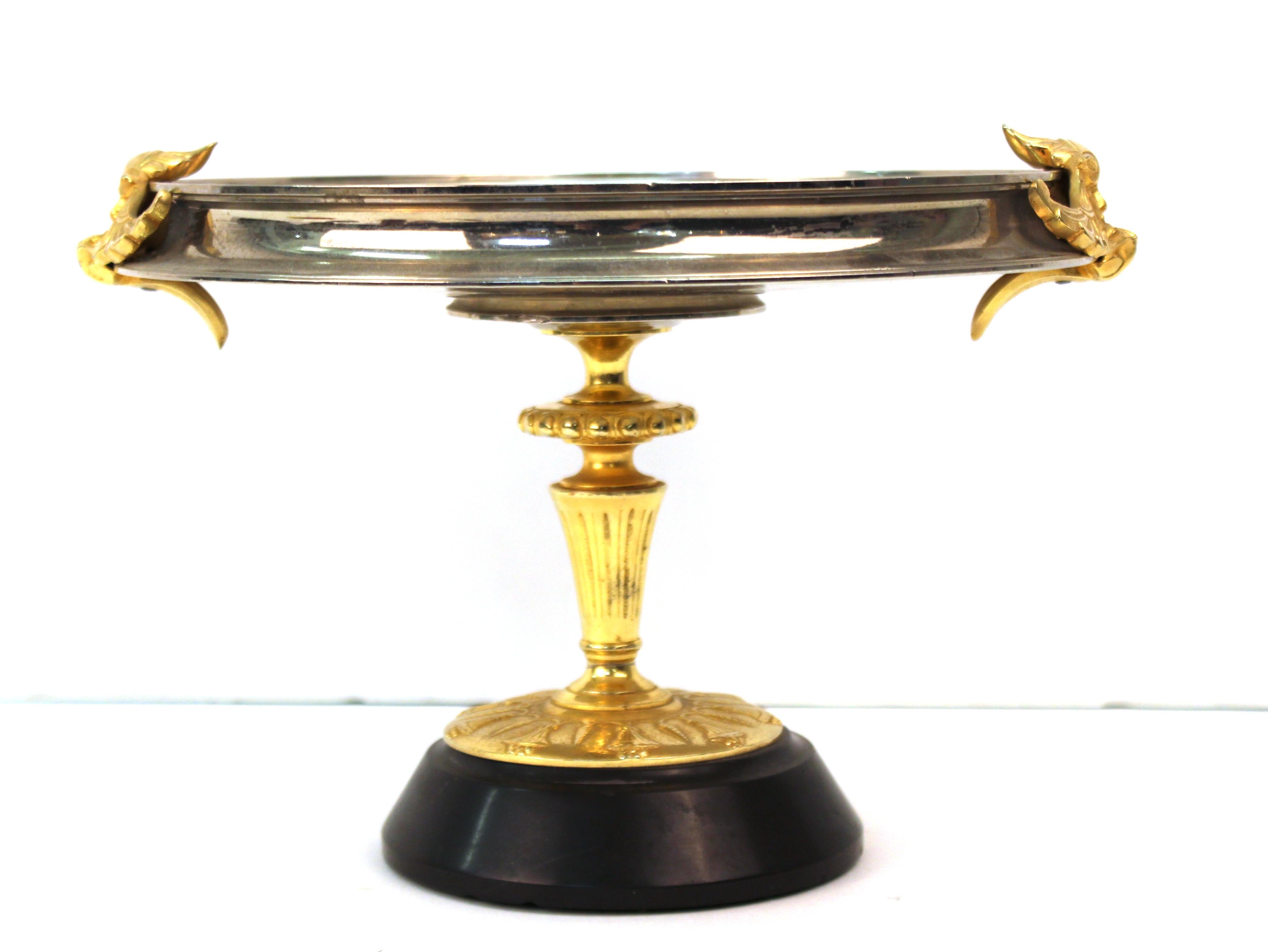 Continental Grand Tour tazza in Neoclassical Revival style, with a decorative central medallion featuring a nymph with a cherub. The plate has satyr head handles and is mounted on a gilt base with Neo-Egyptian base. In great vintage condition with