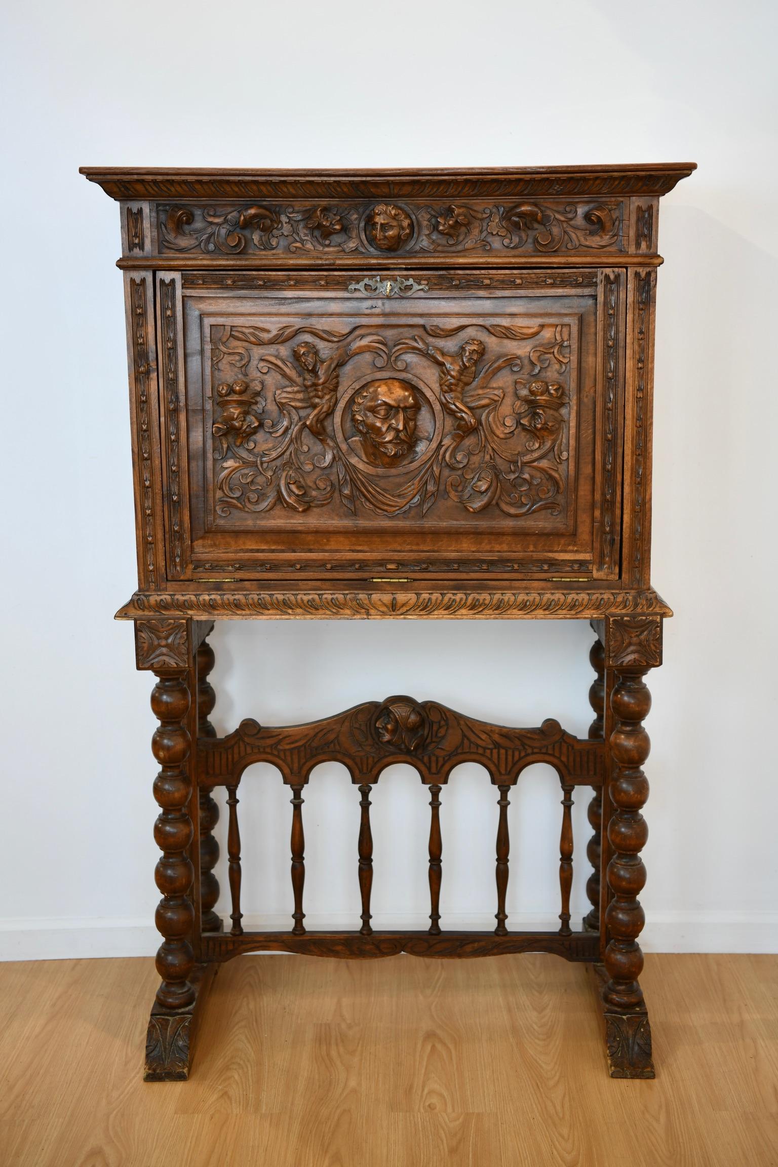 Continental drop down abattant with floral and figural carvings on base. Dimensions: 61.5