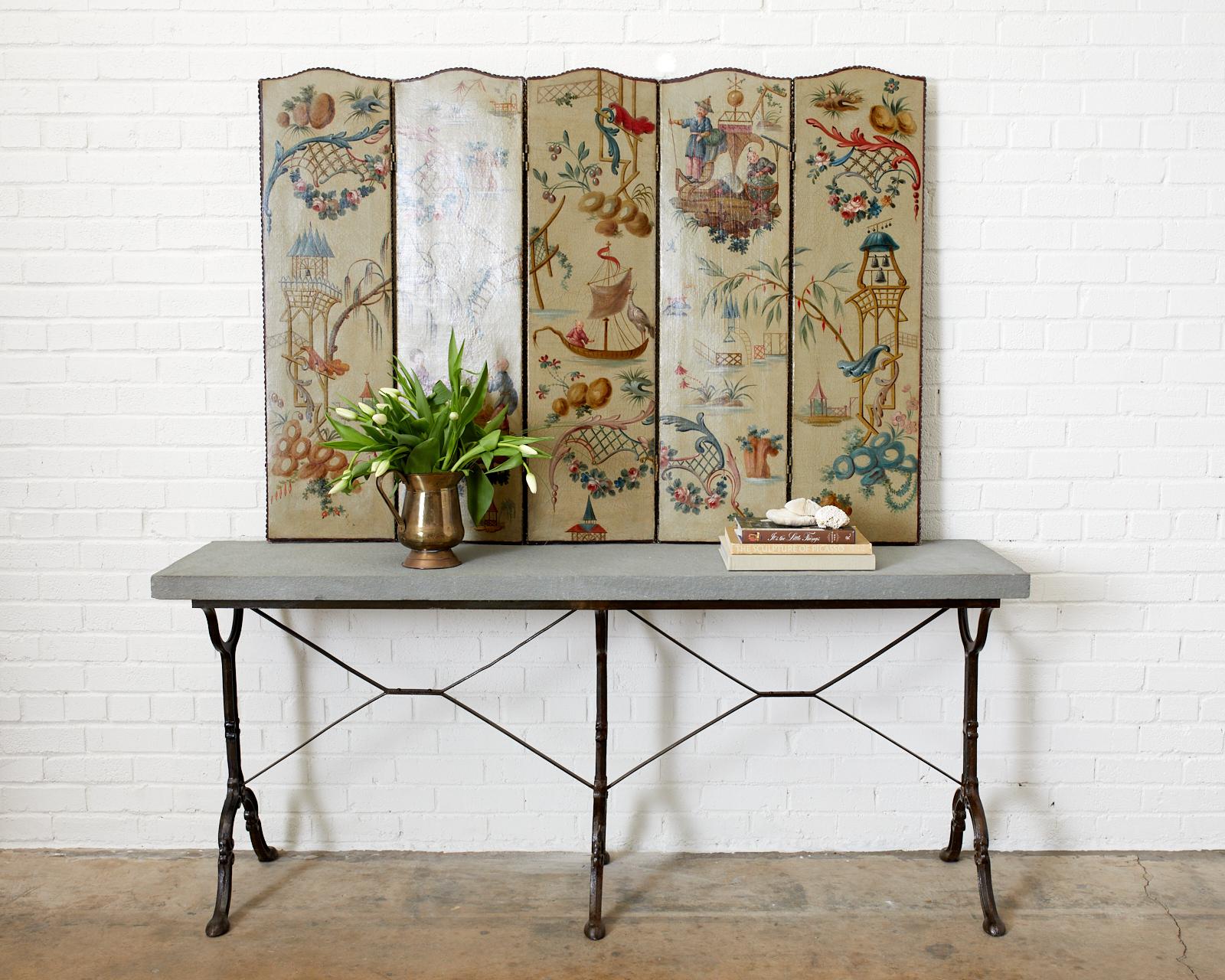 Charming five-panel folding screen featuring hand painted canvas panels decorated in the chinoiserie revival period of the early 20th century, Europe. Constructed from wood frames covered with canvas and bordered with brass tack nail heads. The