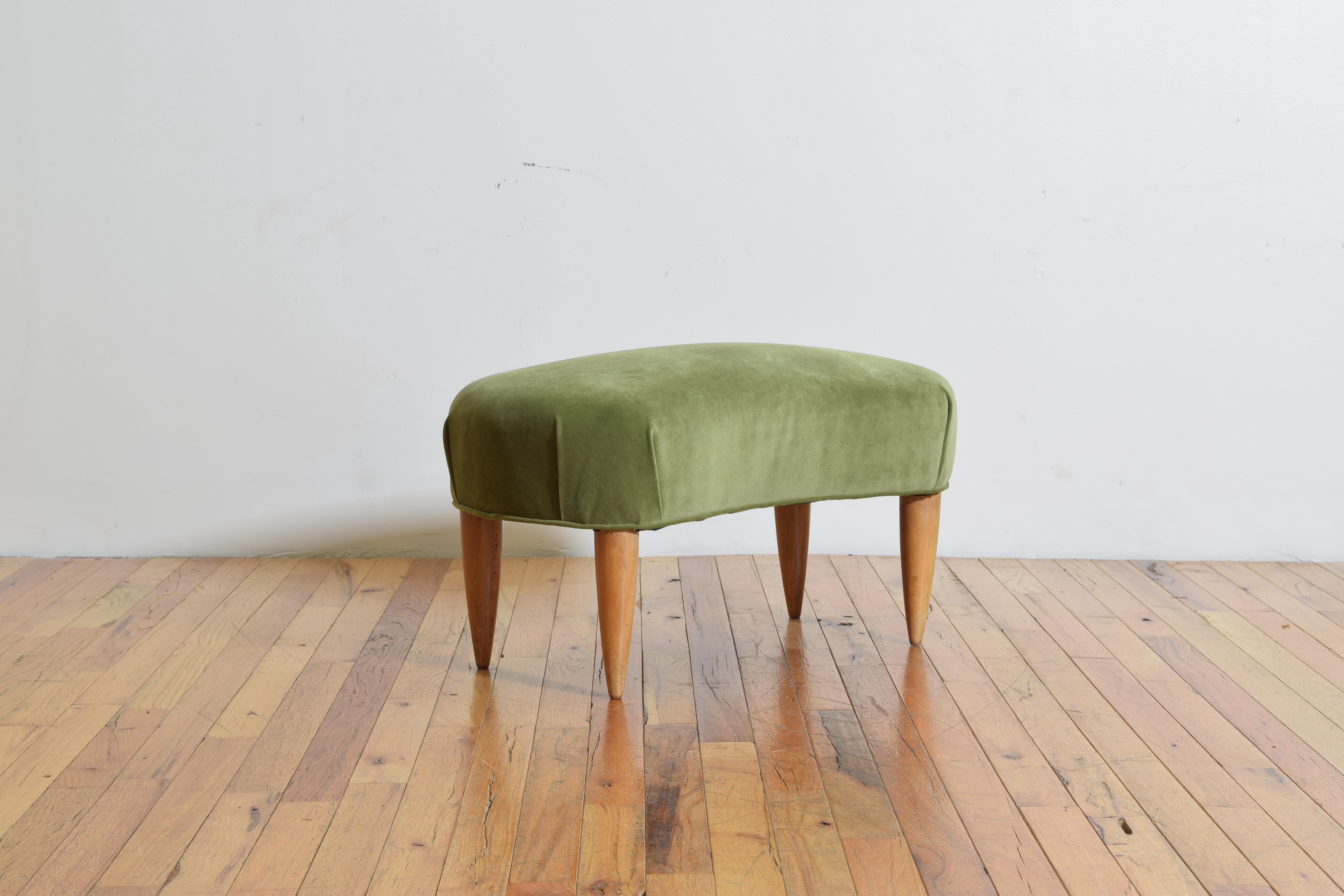 Having an upholstered kidney shaped top, raised on circular tapering legs.
