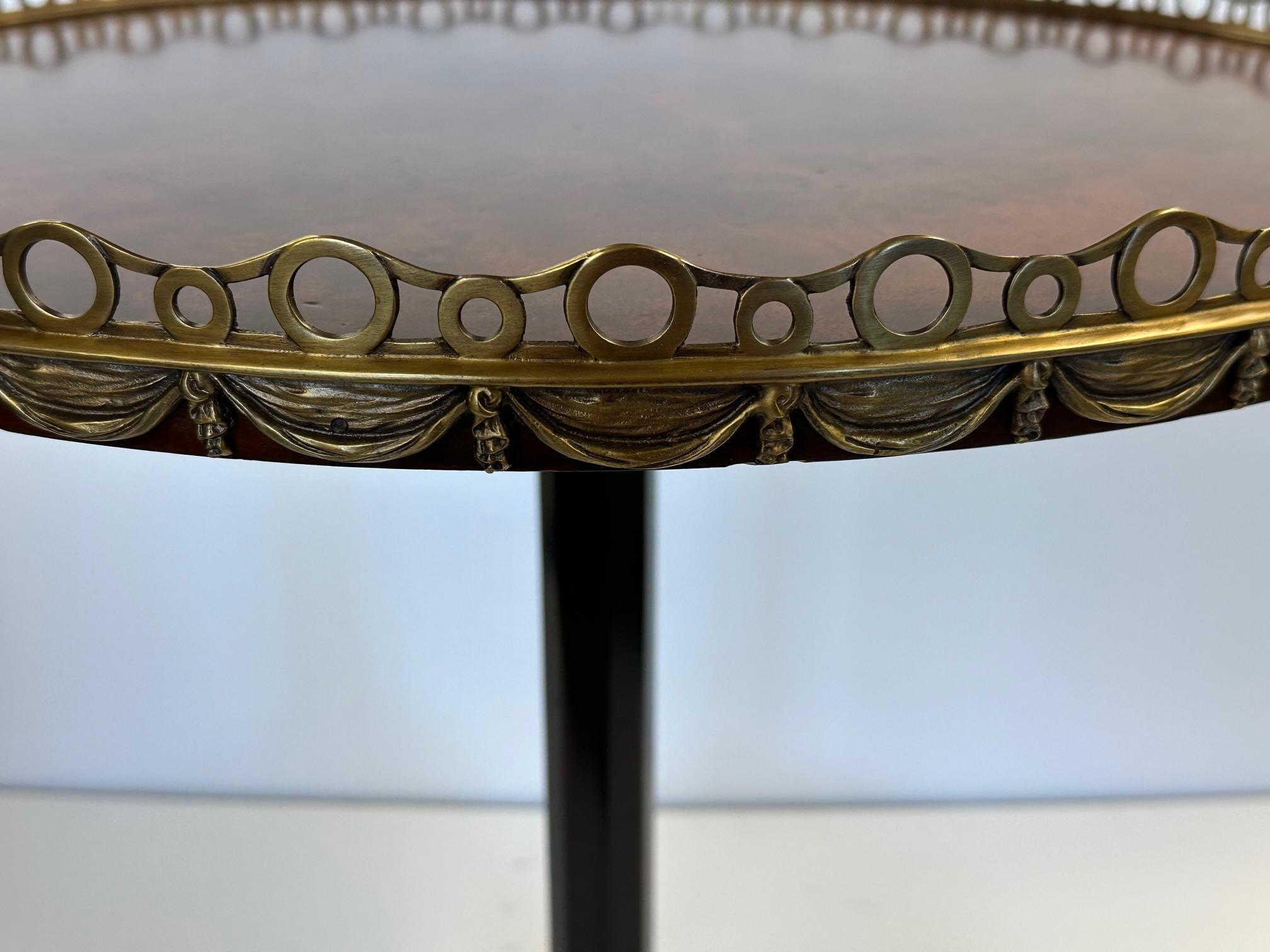 Eleganter runder Mahagoni-Beistelltisch mit Wurzelholzplatte und Bronzegalerie sowie Bronzebeschlägen.  Hübsche Stativbeine.