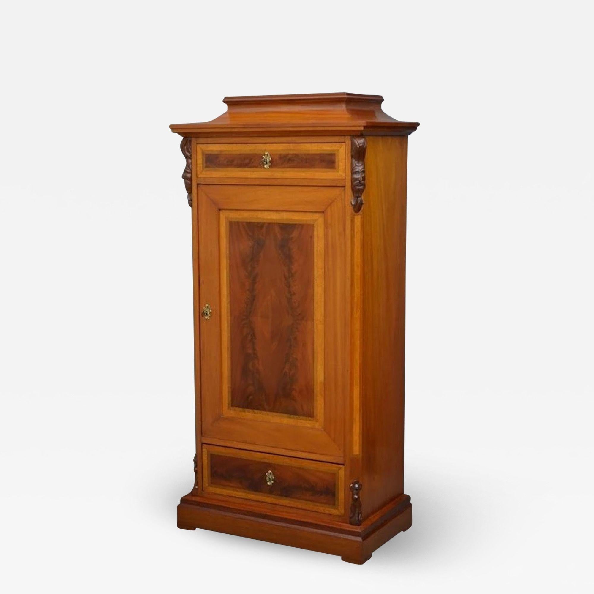 Sn3931, an attractive Continental side cabinet in mahogany, having caddy top above frieze drawer and a booked match quarter veneer door with original working lock and key enclosing three shelves and flamed mahogany drawer to base, all flanked by