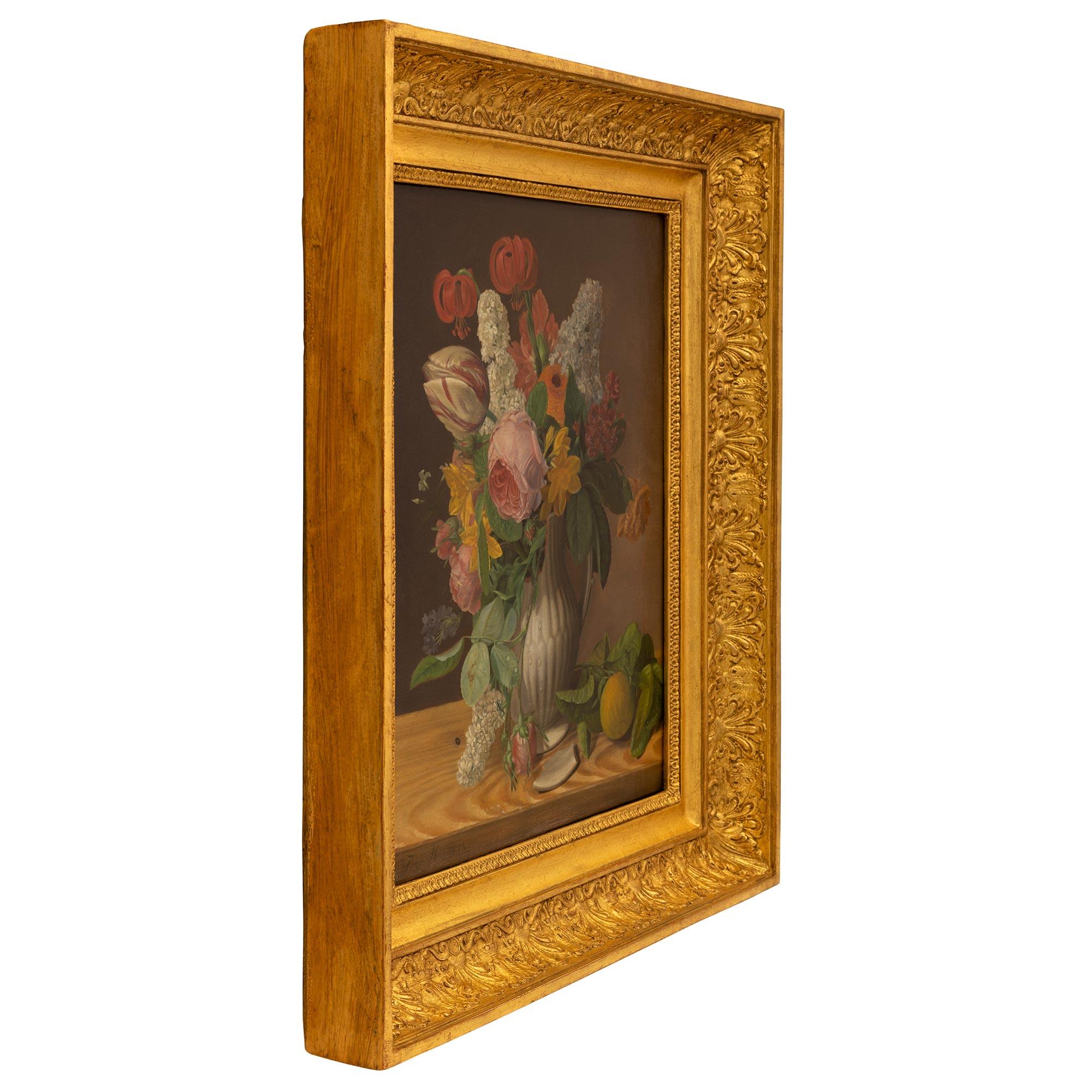 A charming and most decorative Continental mid 19th century still life oil on canvas painting in its original giltwood frame. The painting depicts a lovely finely detailed bouquet of flowers with wonderful vibrant colors in a reeded vase with a