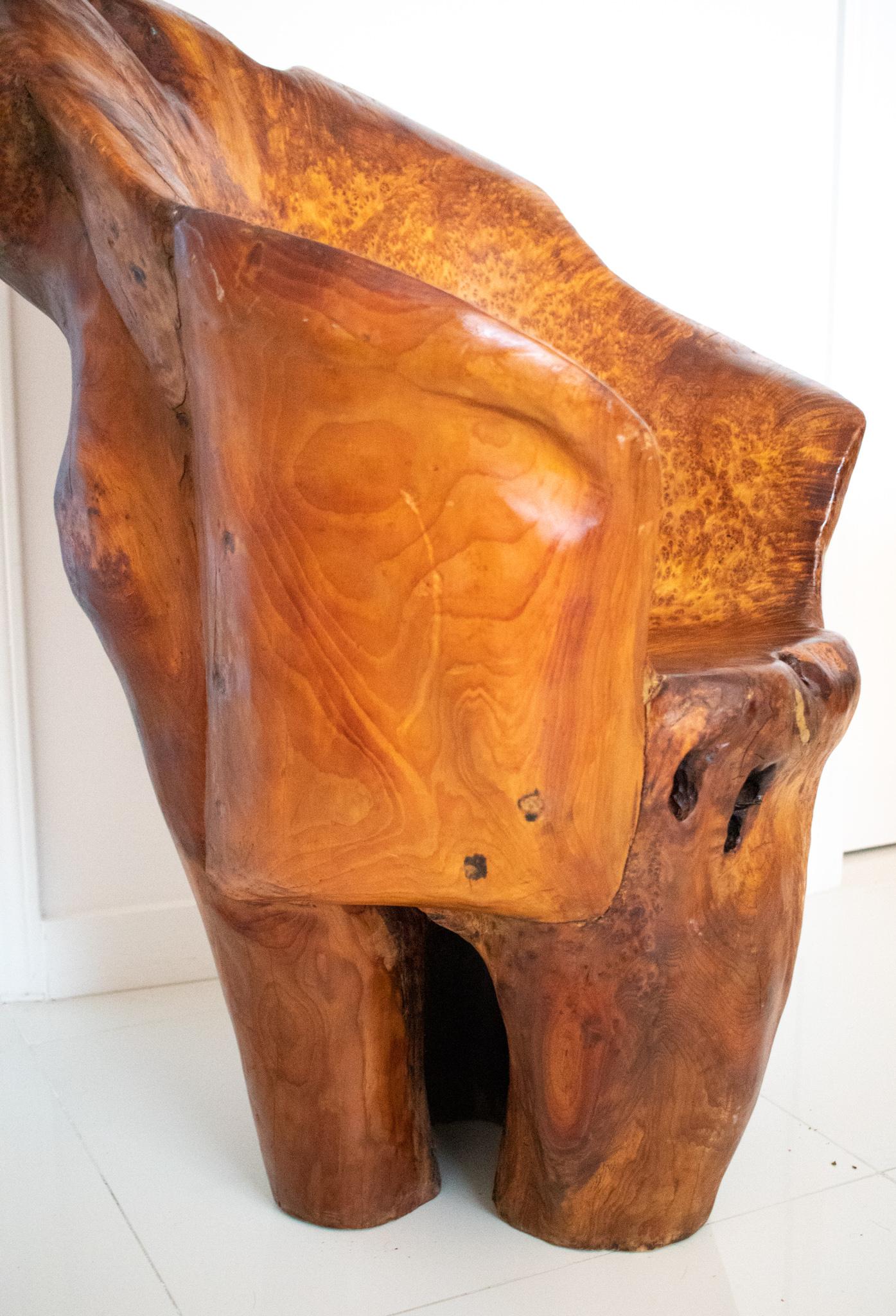 An statement seat carved in precious Burl wood.

Monumental modernist piece, created in America back in the 1960. This seat has been carefully carved in one single piece of Burl wood and rest in three legs integrated to the design. Actually is very