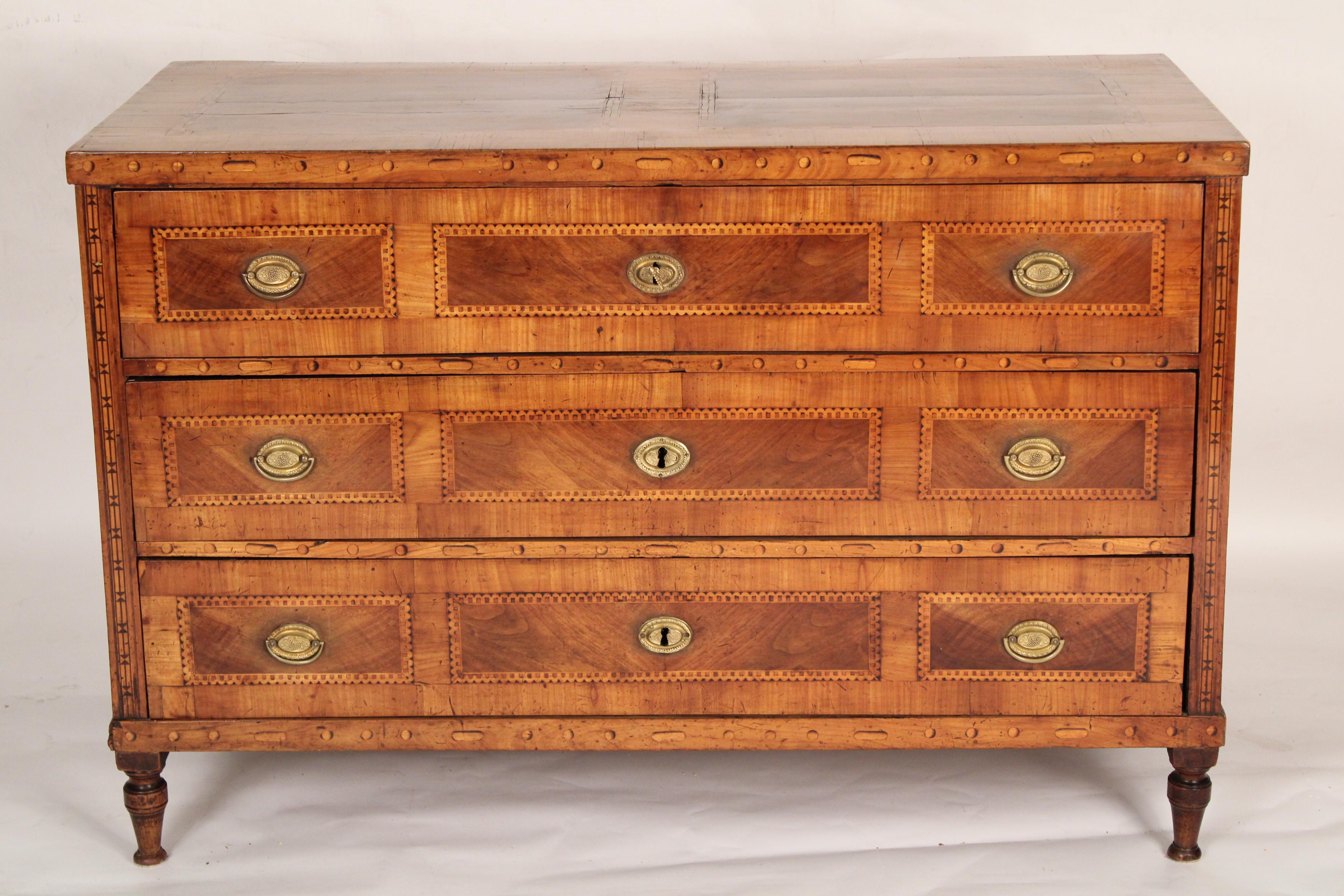 Northern European neo classical inlaid birch and walnut chest of drawers, circa 1825. The rectangular top with inset book matched walnut panels with birch framing. The three drawers with walnut panels and birch framing, resting on turned feet. Old