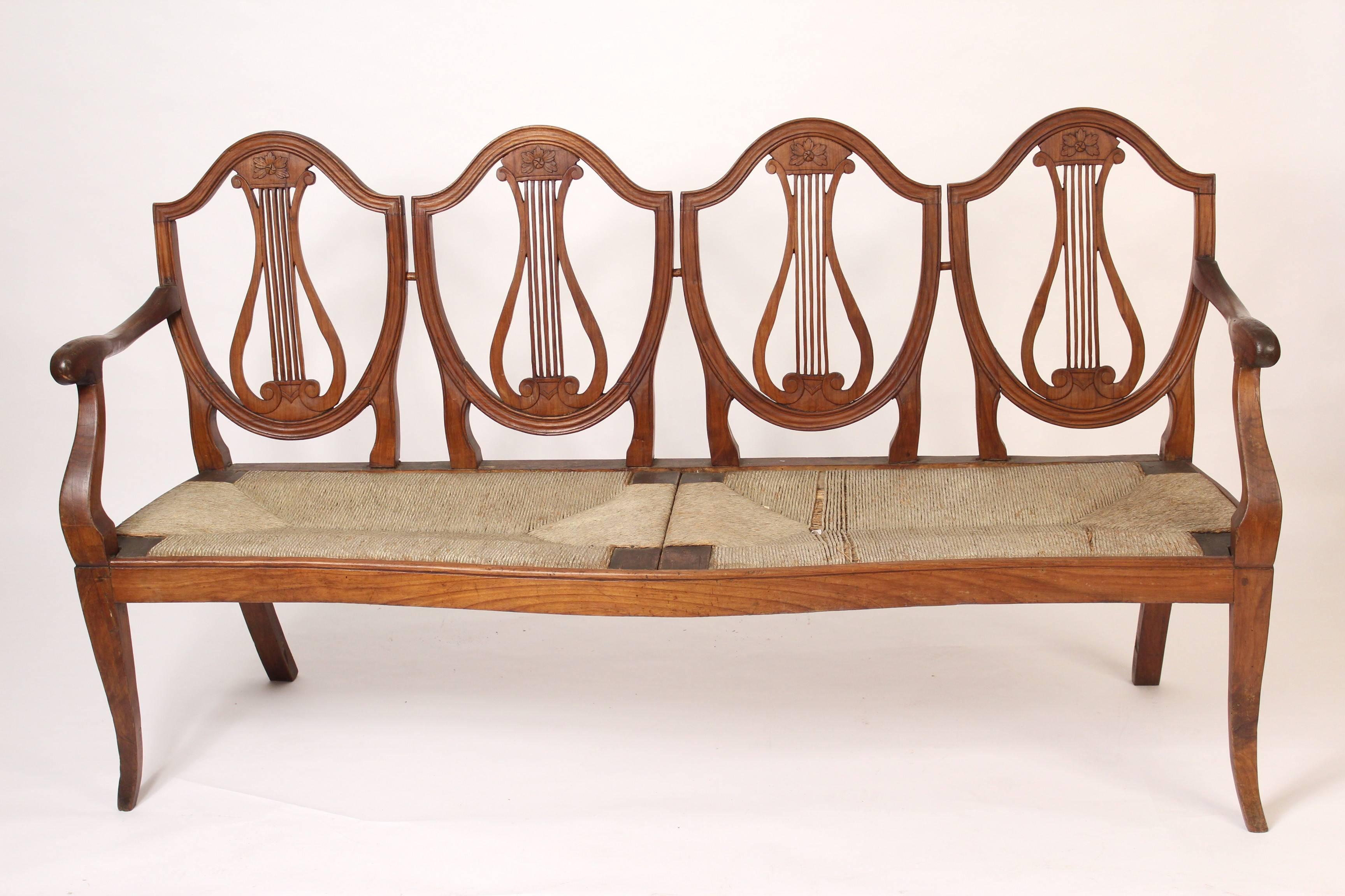 Continental fruitwood neoclassical settee with four shield backs, early 19th century. Measures: Seat height with cushion 20