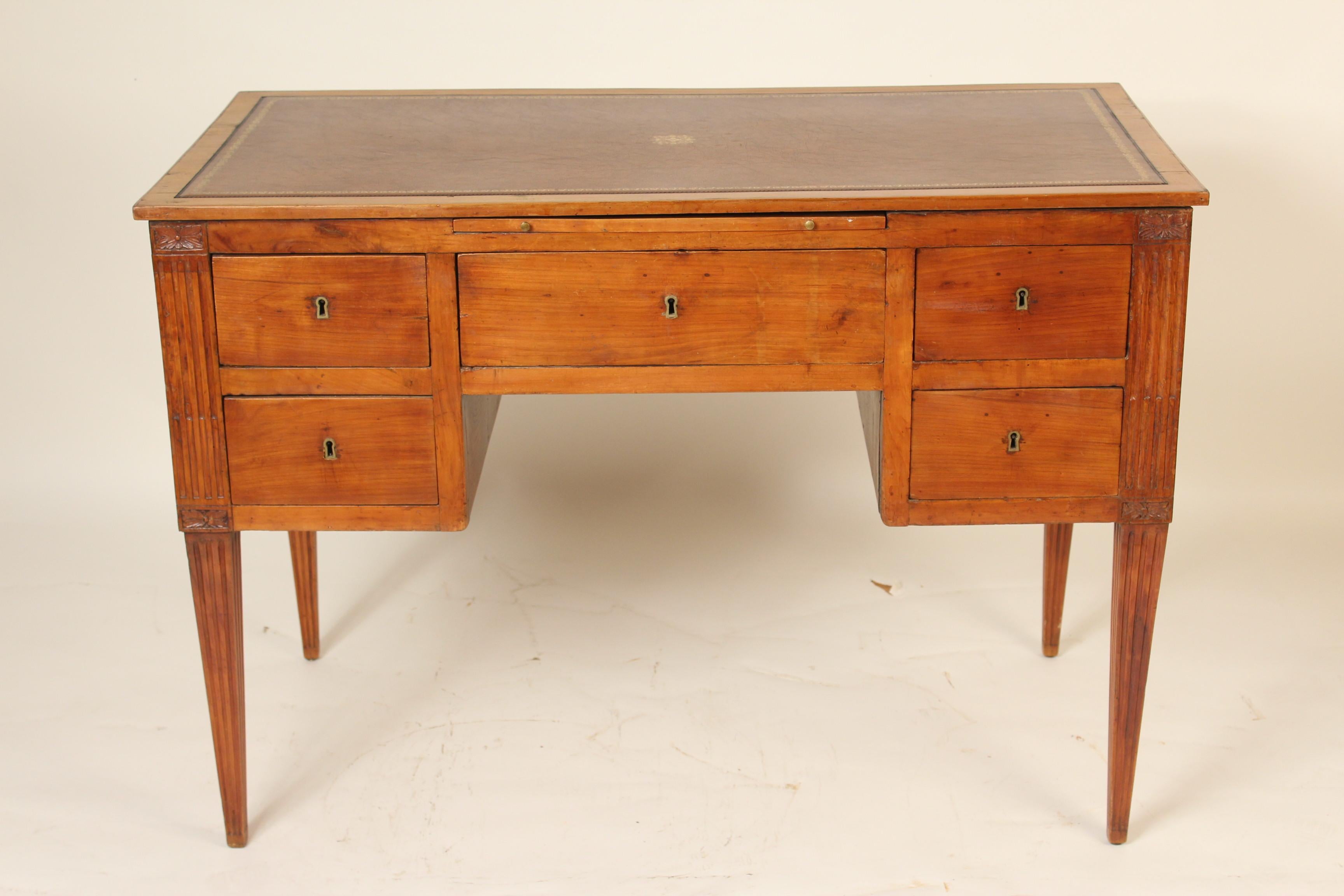 Continental neoclassical fruitwood desk, 19th century, with a 21st century tooled leather top. This desk has excellent old fruitwood color. Drawers have dove tail construction. There is a tooled leather writing slide that pulls out.