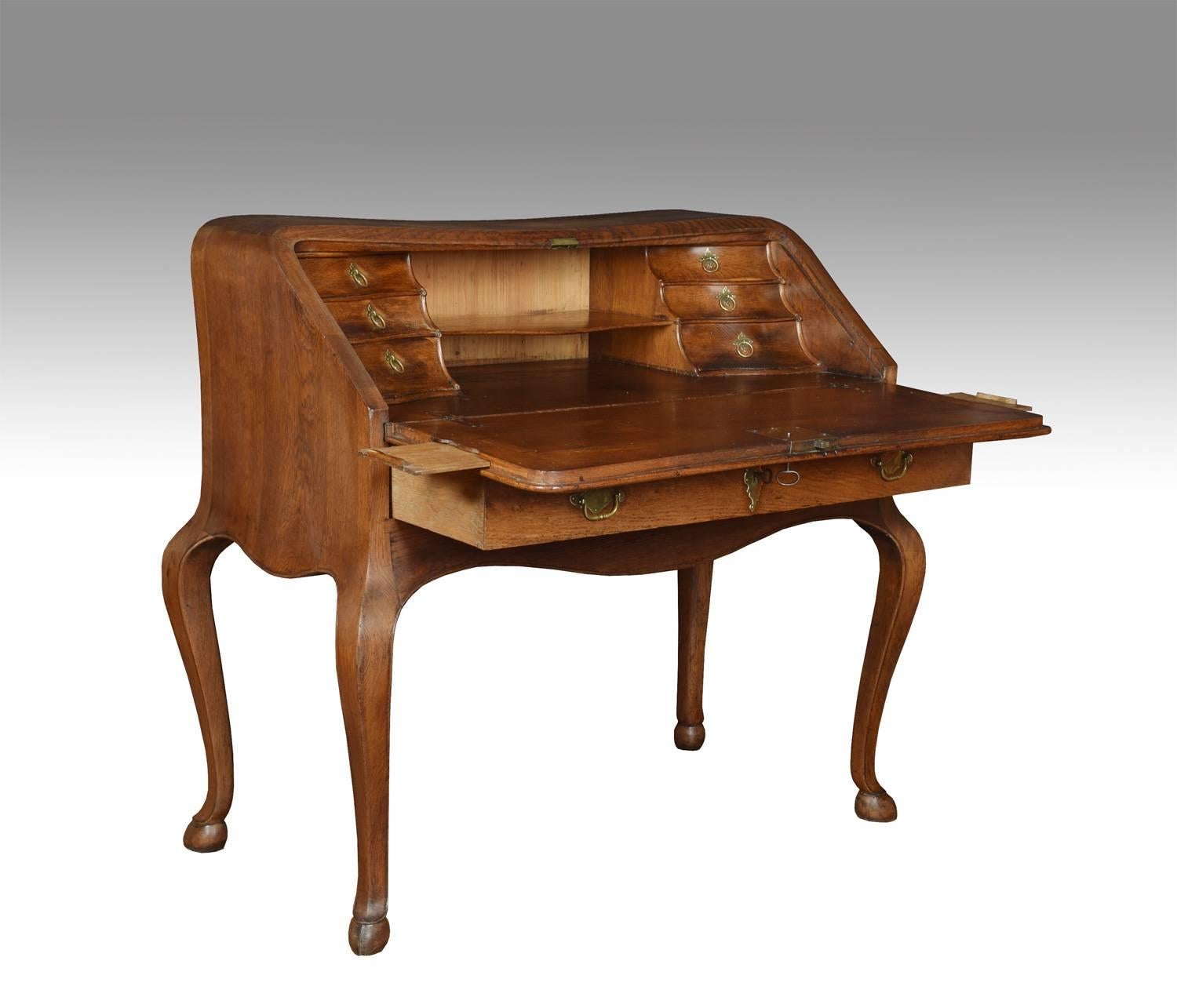 Continental oak bureau, the serpentine shaped top to the fall front opening to reveal a fitted interior, of draws and pigeon holes surrounding a large writing surface with pull-out candle holders, with a large single draw below. All raised up on