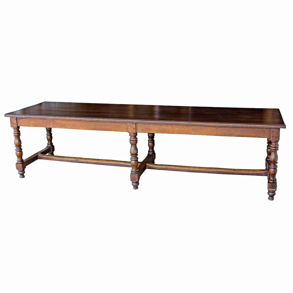 Crafted of solid oak, this refectory style table has generous proportions for those who need space to meet and dine. A central stretcher runs the 118? length of the table, which sits on elegantly turned legs. The wooden peg joinery and a plank style