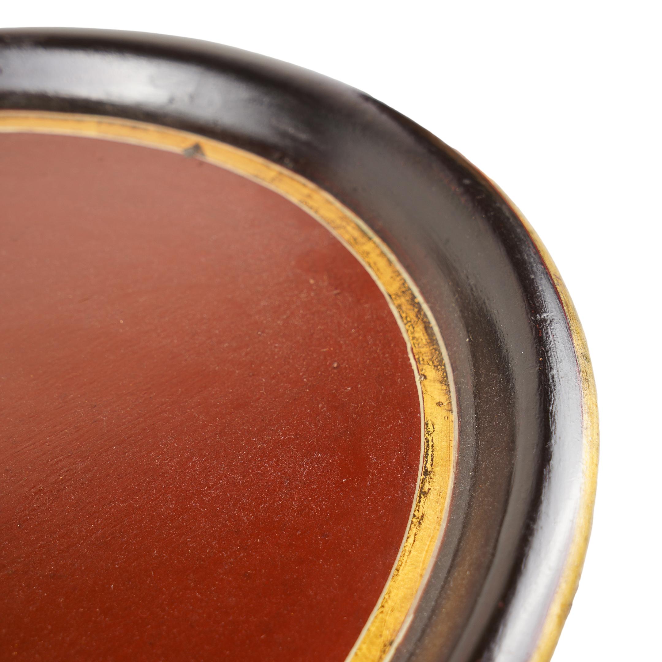 Ovales Teetablett mit vergoldetem Wappen in der Mitte auf burgunderfarbenem Grund, umrahmt von einem schwarzen Rand mit Goldborte.
Kontinental, wahrscheinlich italienisch, zweites Viertel 19. Jahrhundert.