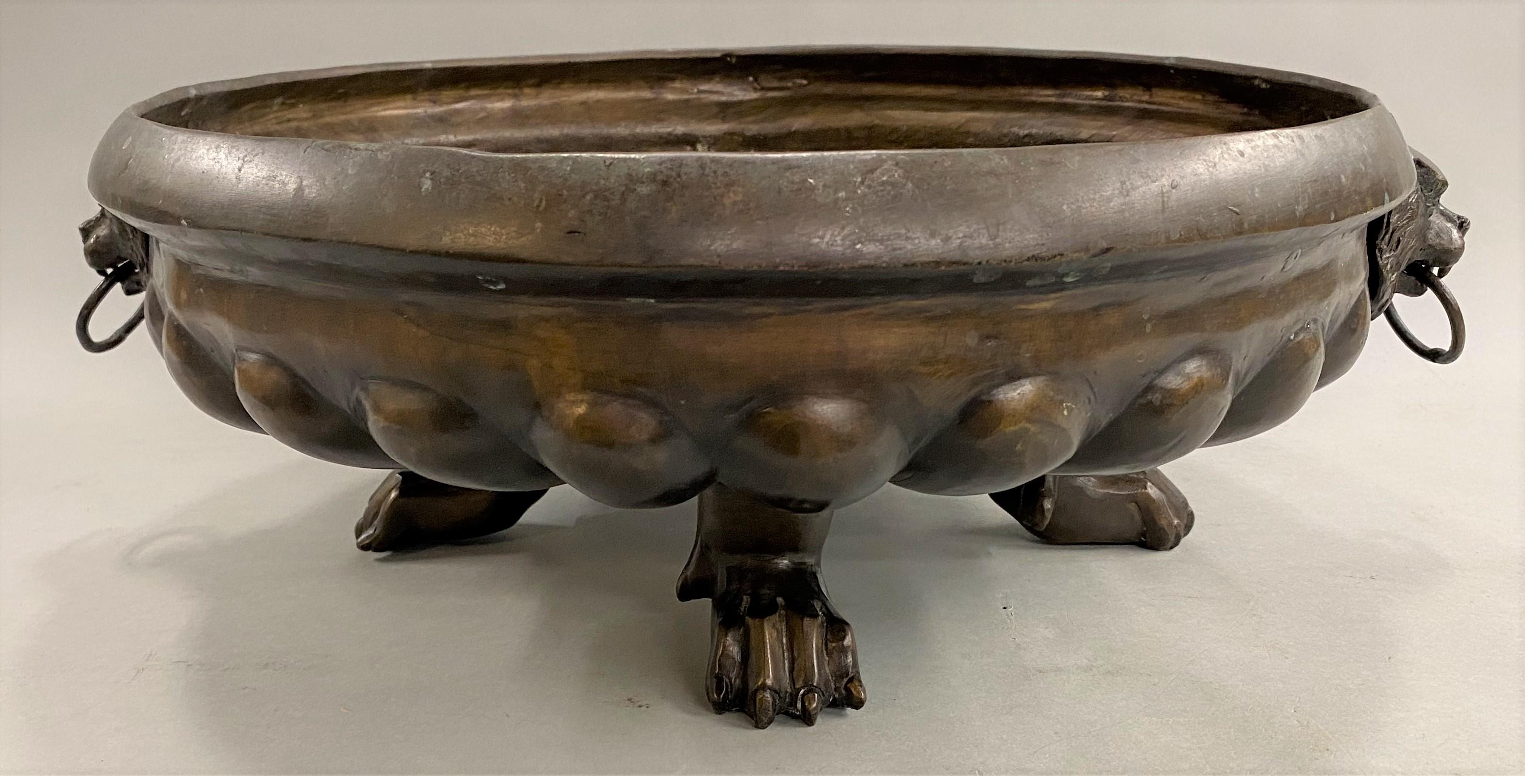 A fine patinated bronze scalloped base bronze jardiniere with lions head ring handles on each side, supported by three paw feet. Continental, dating to the 19th century, in very good overall condition, with minor surface rubs, imperfections, and