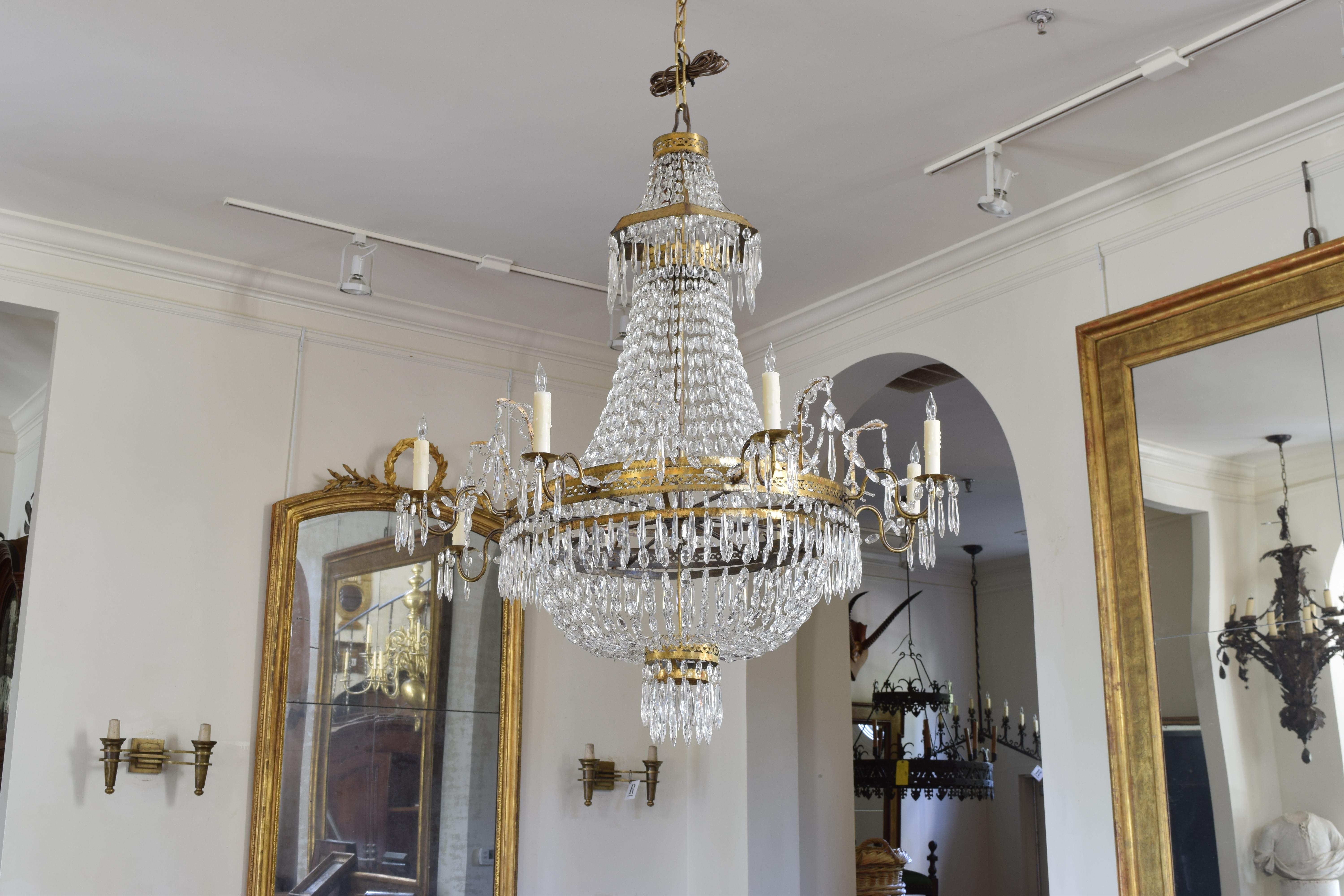 Eight-light chandelier, second quarter of the 19th century. UL wired, beautifully cast and incised brass, all rings with matching piercings and patterns, the top with a pagoda shape, having antique bead chains and prisms, out wired.