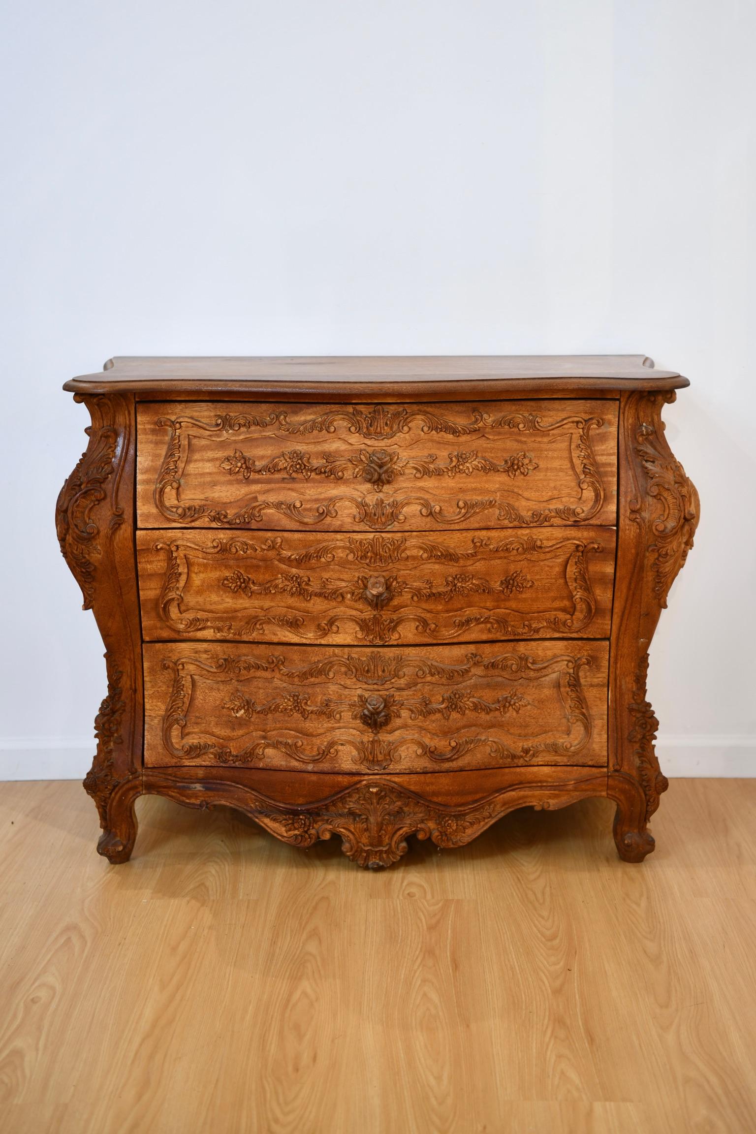 Continental rococo style heavily carved exotic hardwood bombe chest of drawers, circa mid to late 20th century. Dimensions: 34