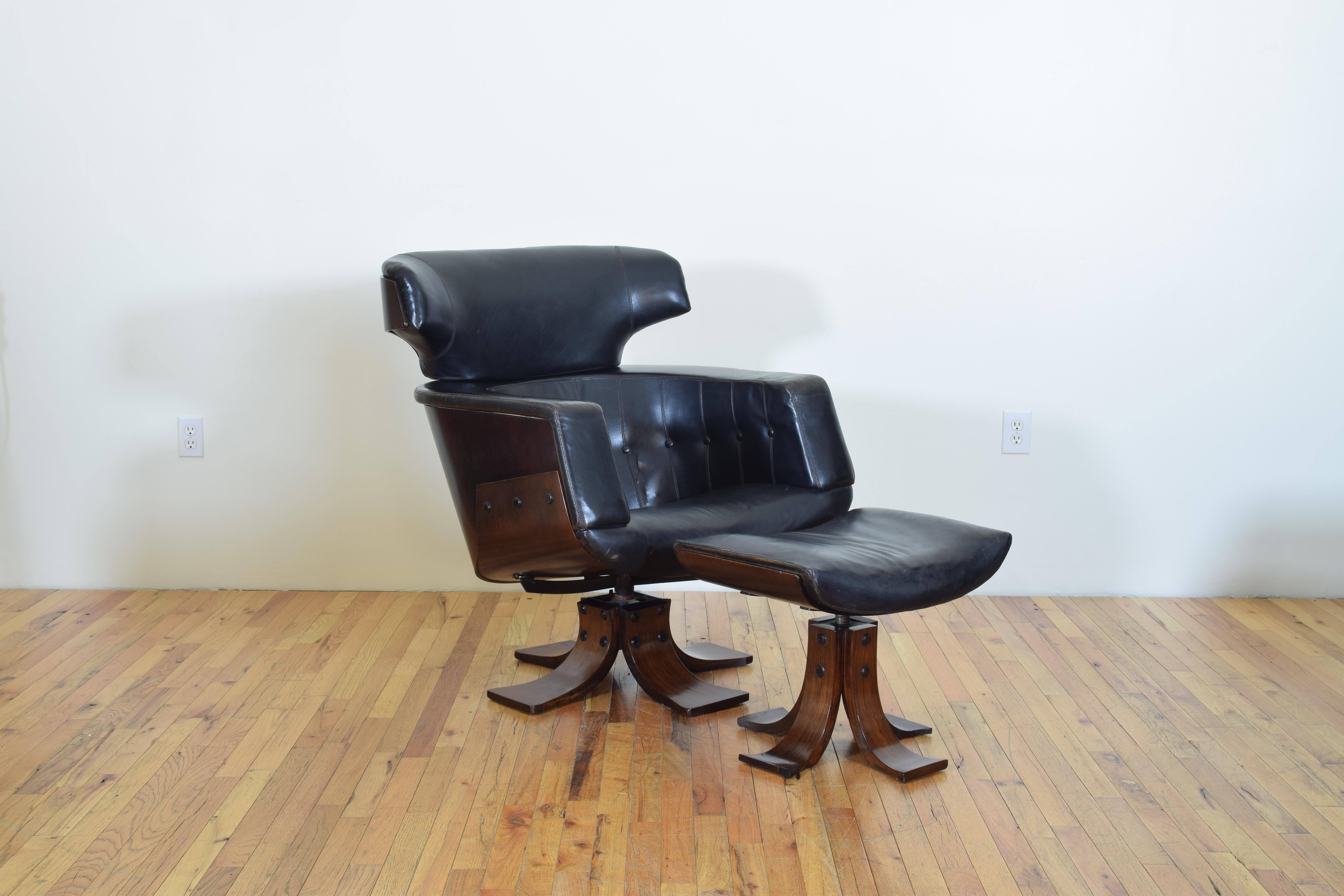 Swiveling movement, flat black leather upholstered with white stitching, the outer sides and rear veneered in rosewood, with matching ottoman.