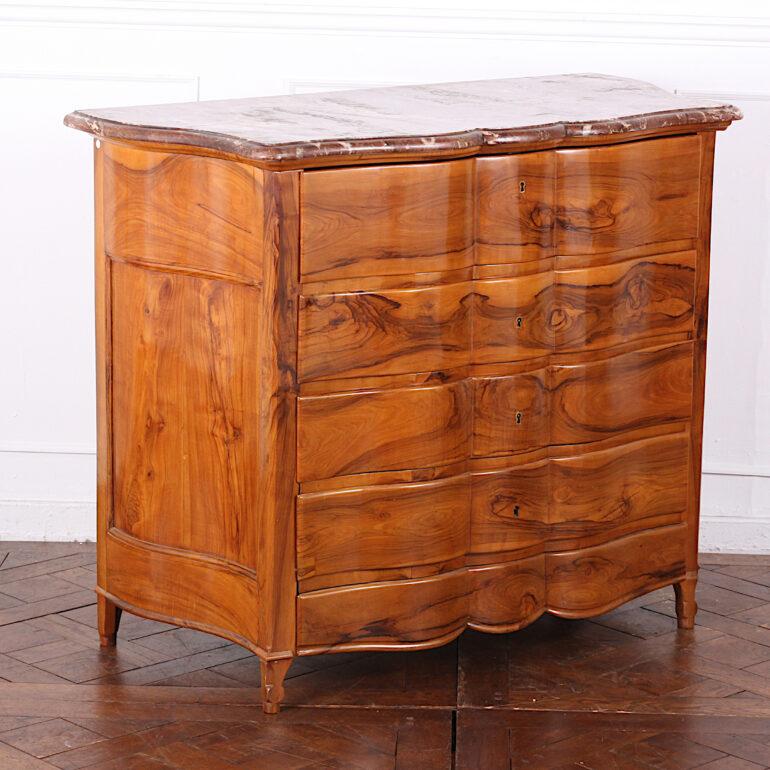 Continental European figured fruitwood marble-top commode having four drawers below a fitted pull-out writing desk. Interior with fitted drawers including two secret ones. Original shaped marble top. 

 