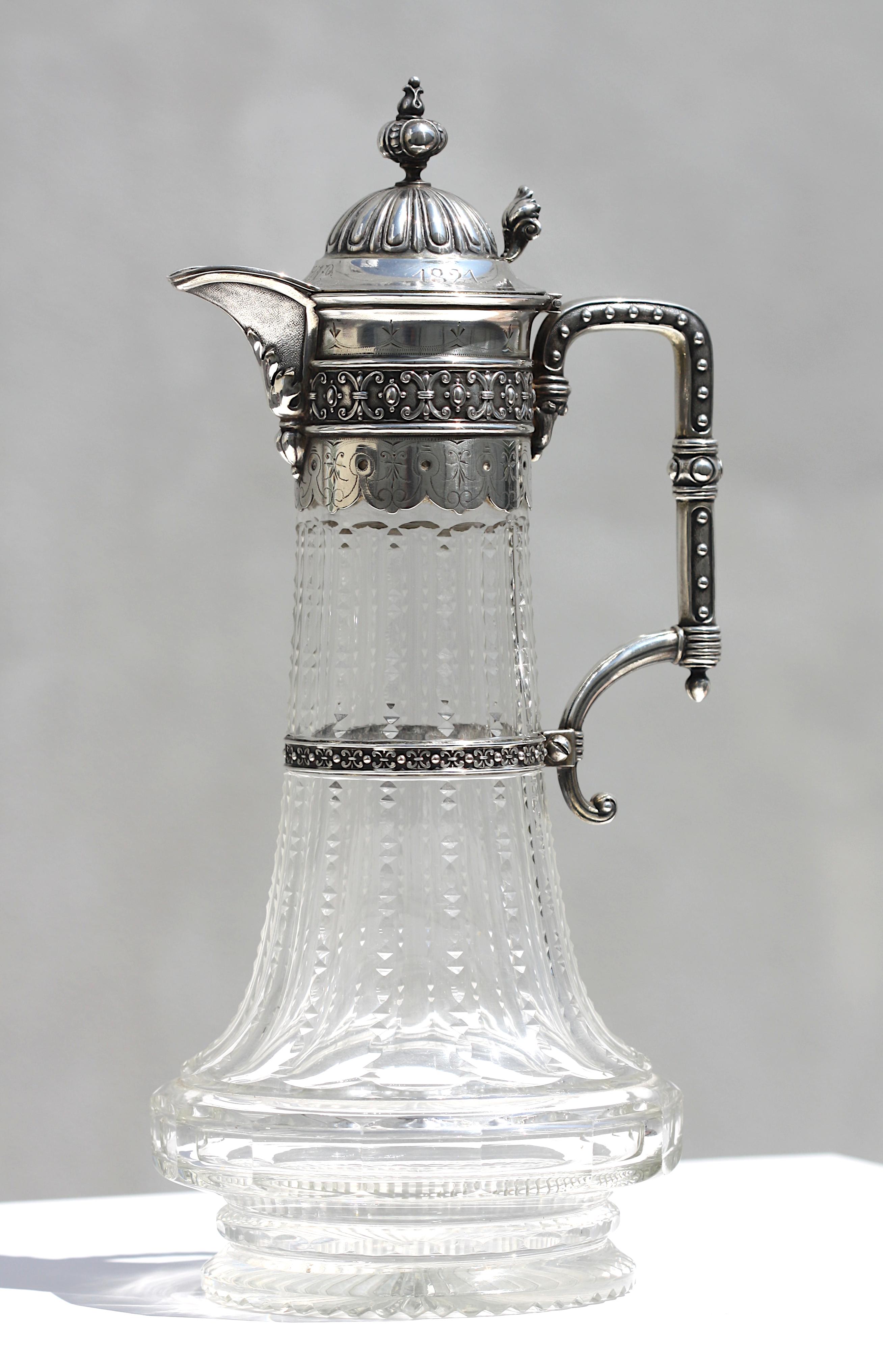 
Continental Silver-Mounted Cut-Glass Wine Carafe
German/Austrian, 1st quarter thru last quarter, 19th Century, marked with a crown before 800, followed by an indistinct symbol, inscribed d. Aug.26, 1821, and monogramed, on the lid.
The faceted-cut