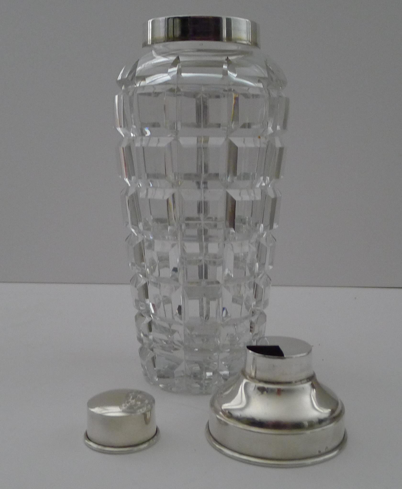 A fabulous hefty cocktail shaker created from a heavy piece of hand-blown crystal beautifully deep cut in a simple and elegant design.  The underside reveals the polished pontil mark.

The collar lid and little top are made from continental silver,