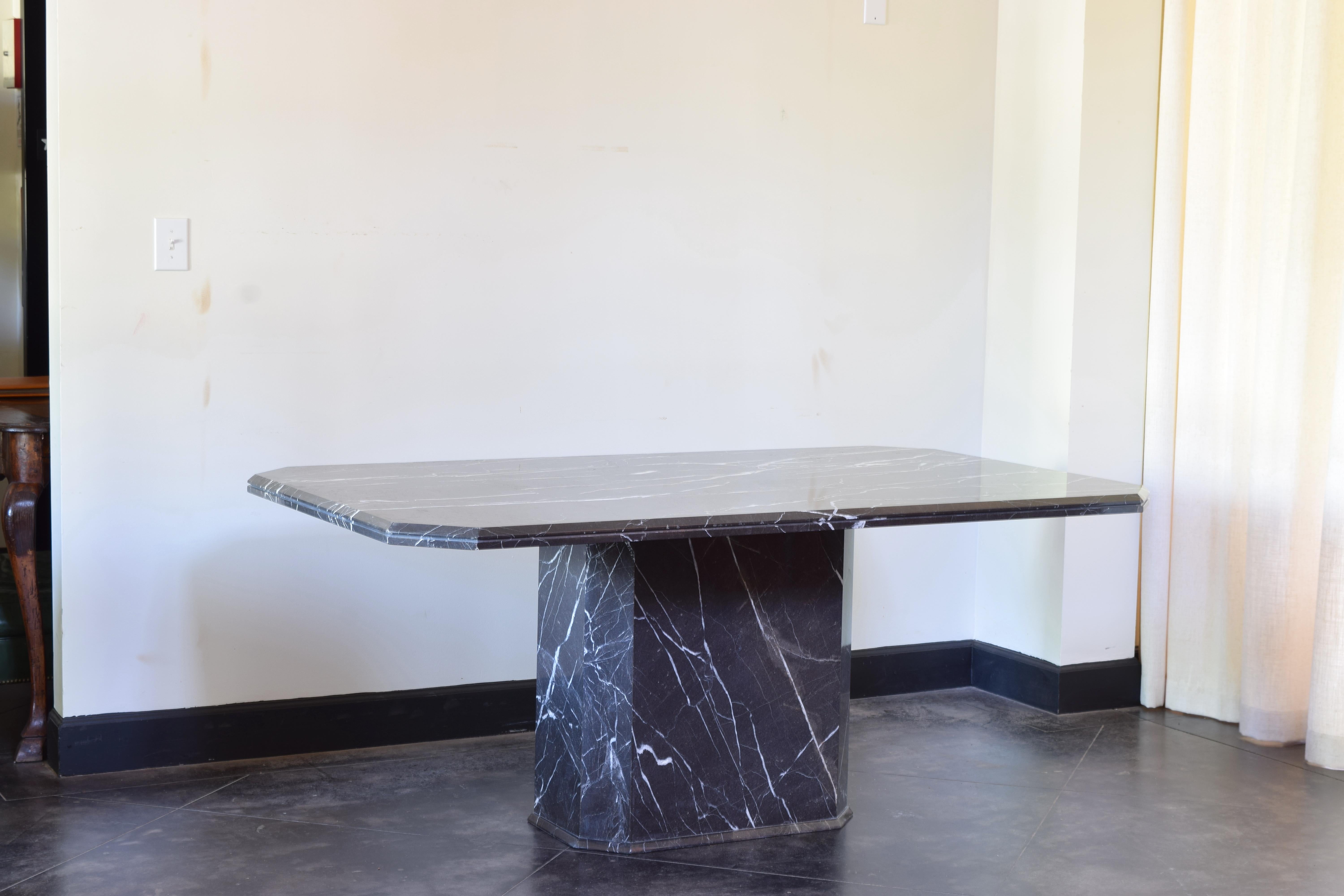 The top a single slab of marble of rectangular shape with canted corners resting atop a central elongated octagonal pedestal with molded edge at base