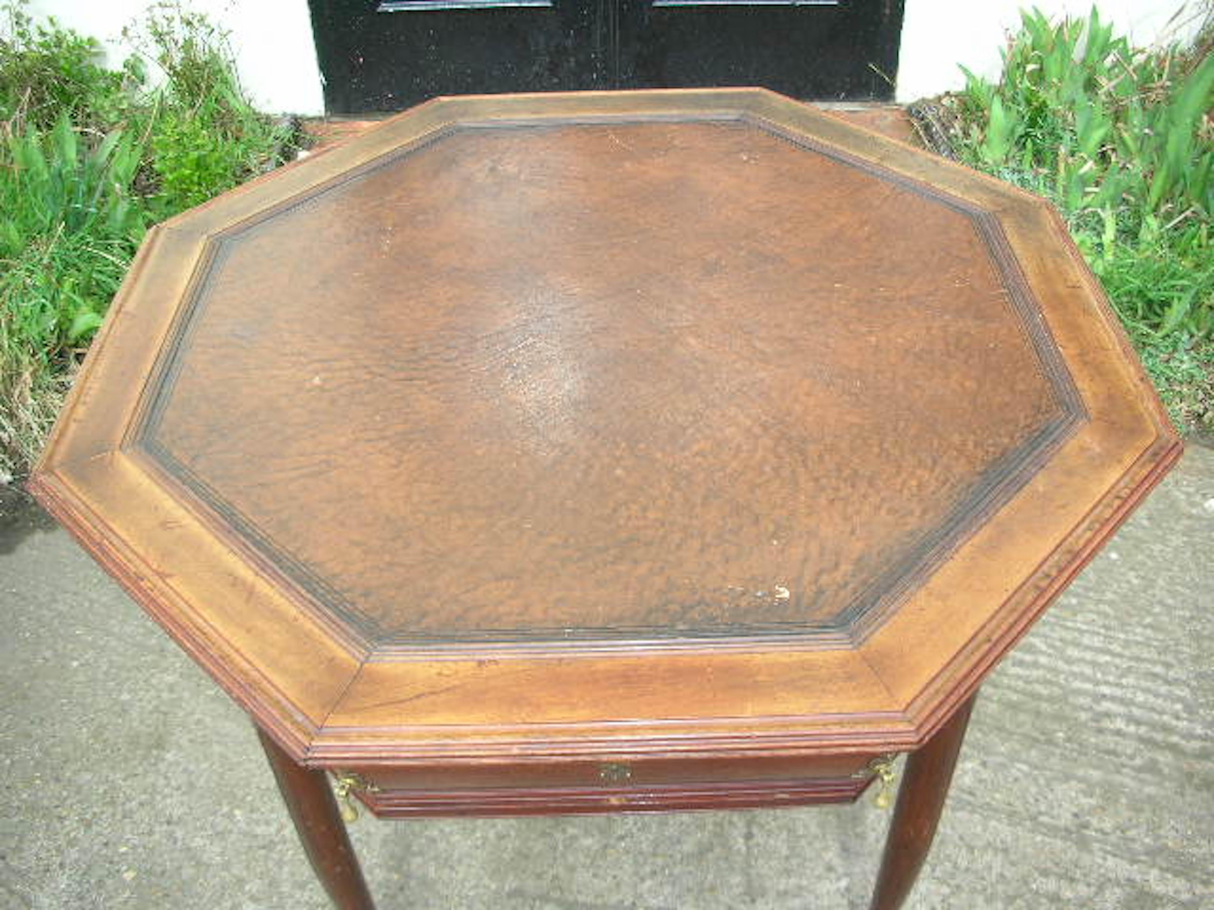 A continental walnut octagonal center table with drawers, circa 1900, in the manner of Henry Van der Velde, the leather inset top with border tramlines, two opposing frieze drawers with conforming mouldings, on four swelling rounded and moulded legs