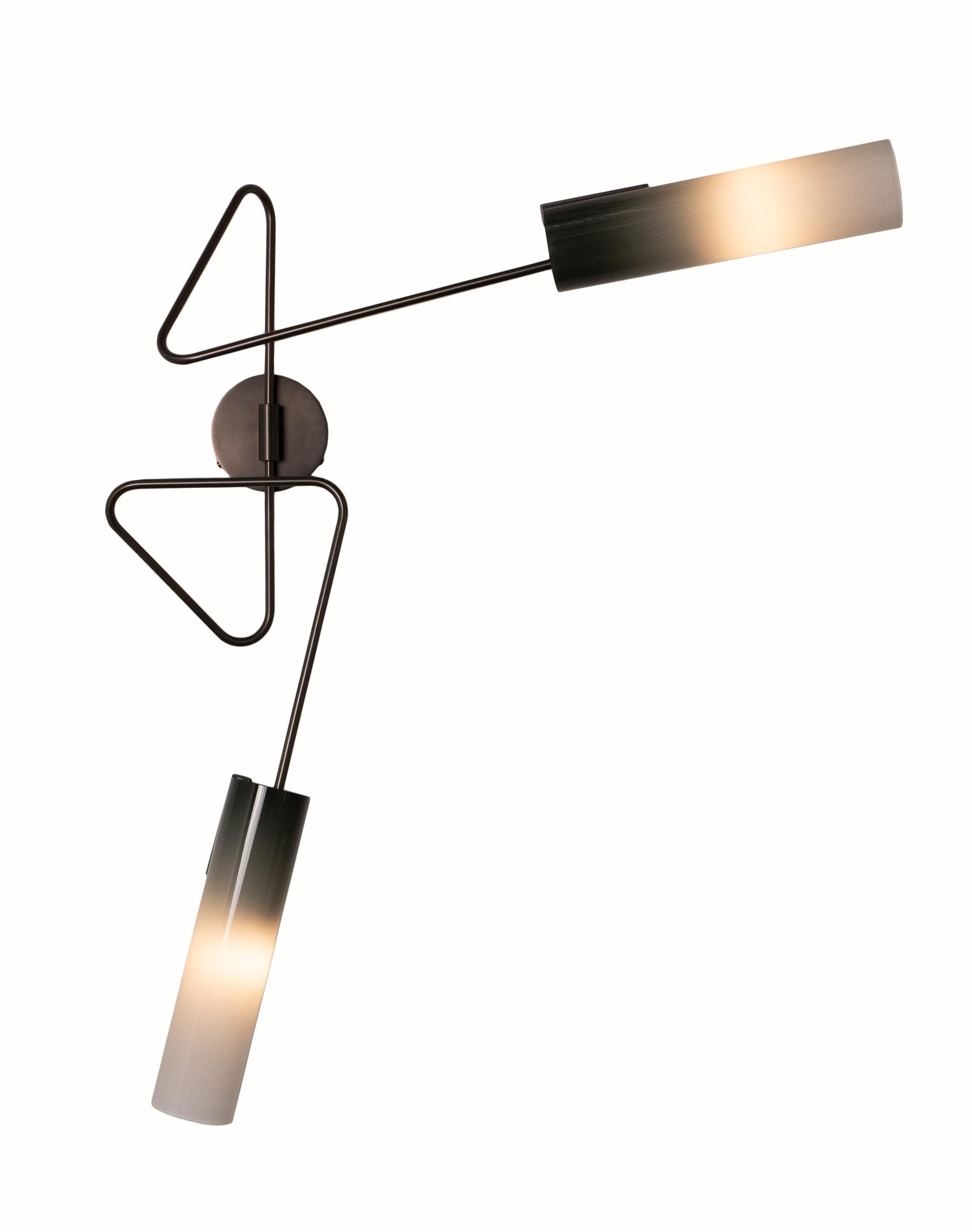 The Continuum collection was inspired by New York’s vibrant street art. The structure consists of a set of custom bent brass tubes that can be arranged in a variety of ways to produce a multitude of styles and sizes. The hand blown glass shades are