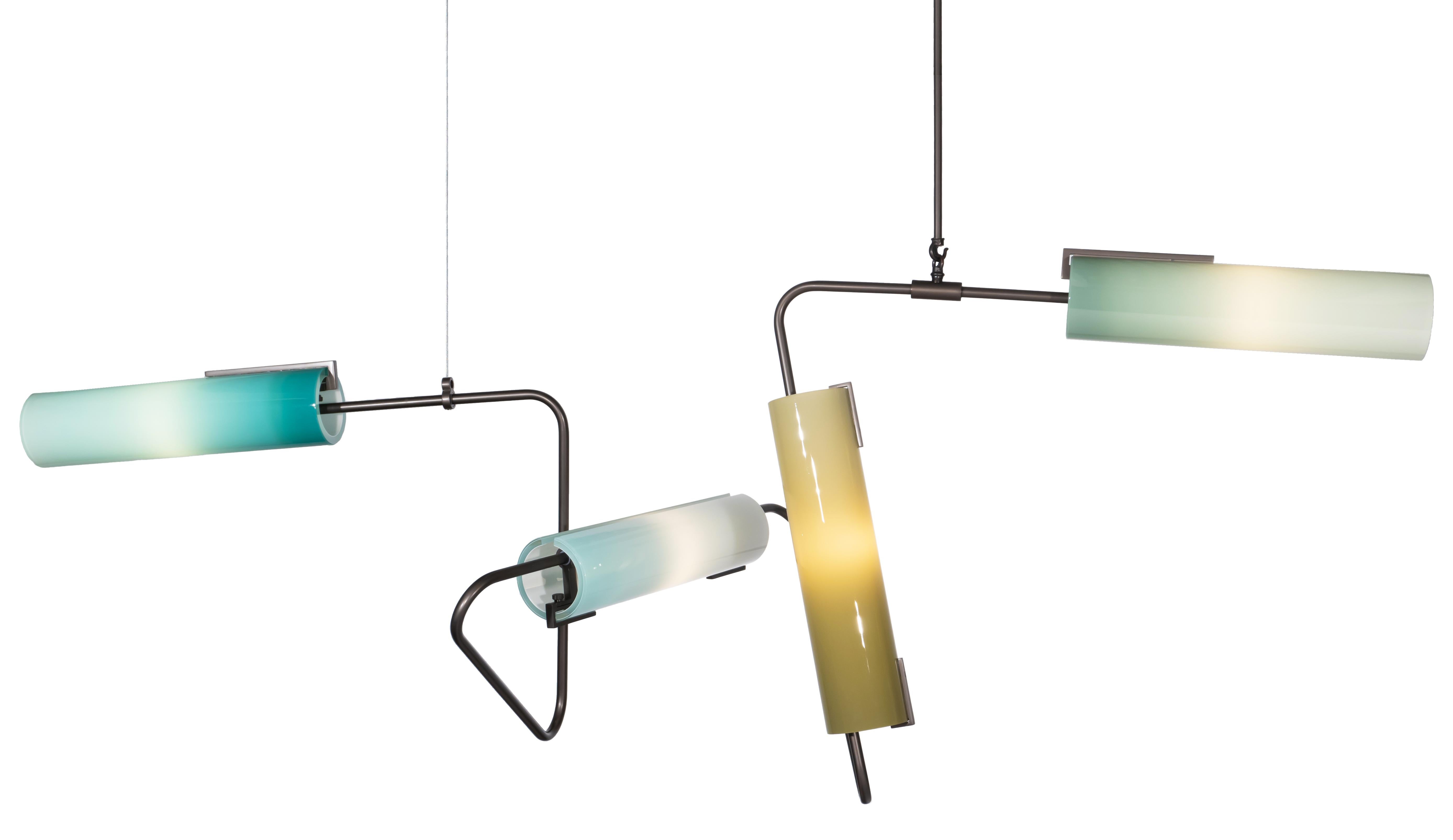 The Continuum Collection was inspired by New York’s vibrant street art. The structure utilizes custom bent tubes that can be connected and arranged in a variety of ways to produce a multiple styles and sizes. The hand blown glass shades are