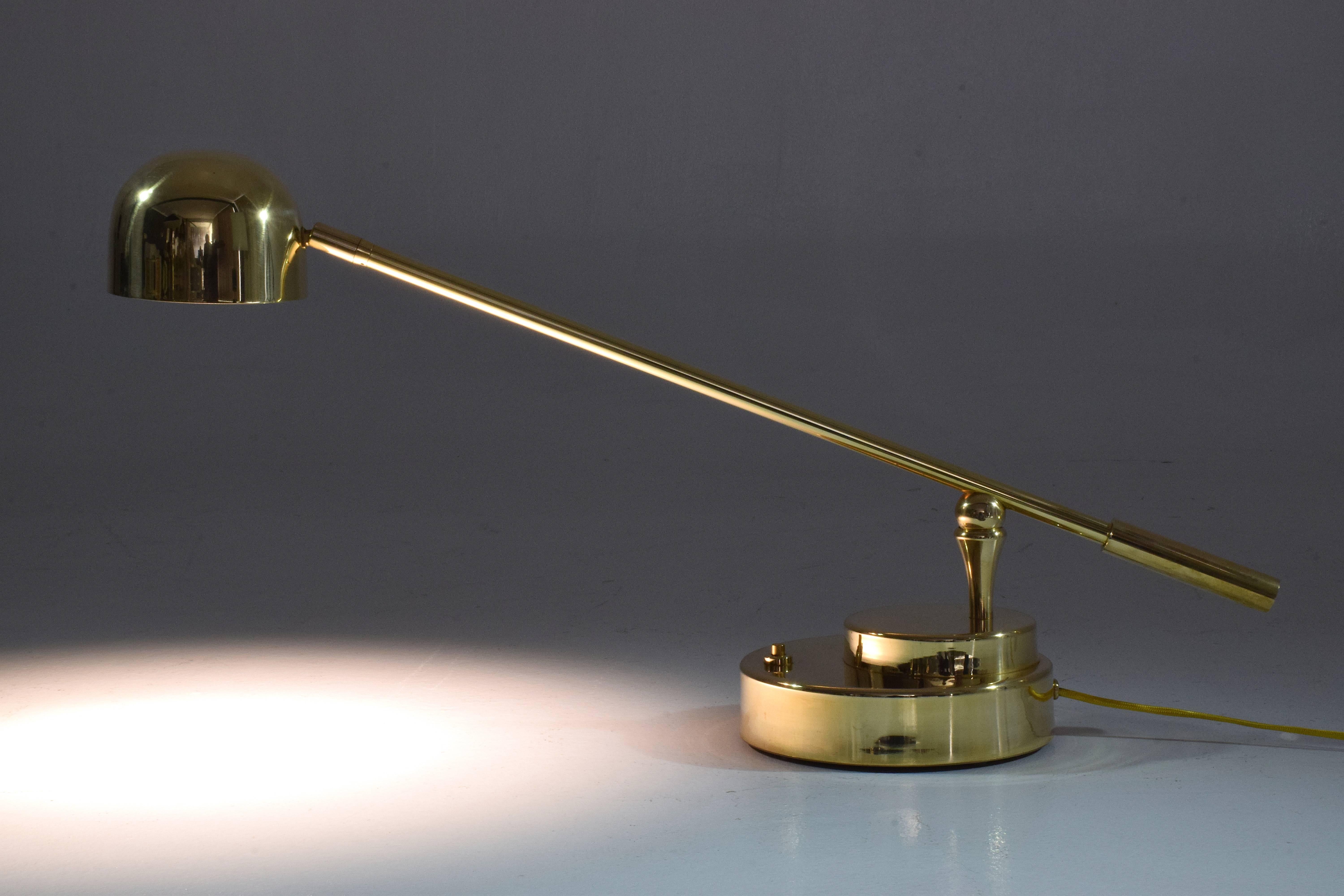 Contemporary handcrafted desk or accent lamp composed of a solid polish brass structure and designed with an adjustable stem and a rotatable shade. This piece rotates around two axis: the shade and the base. The Continuum-I Model III is part of the