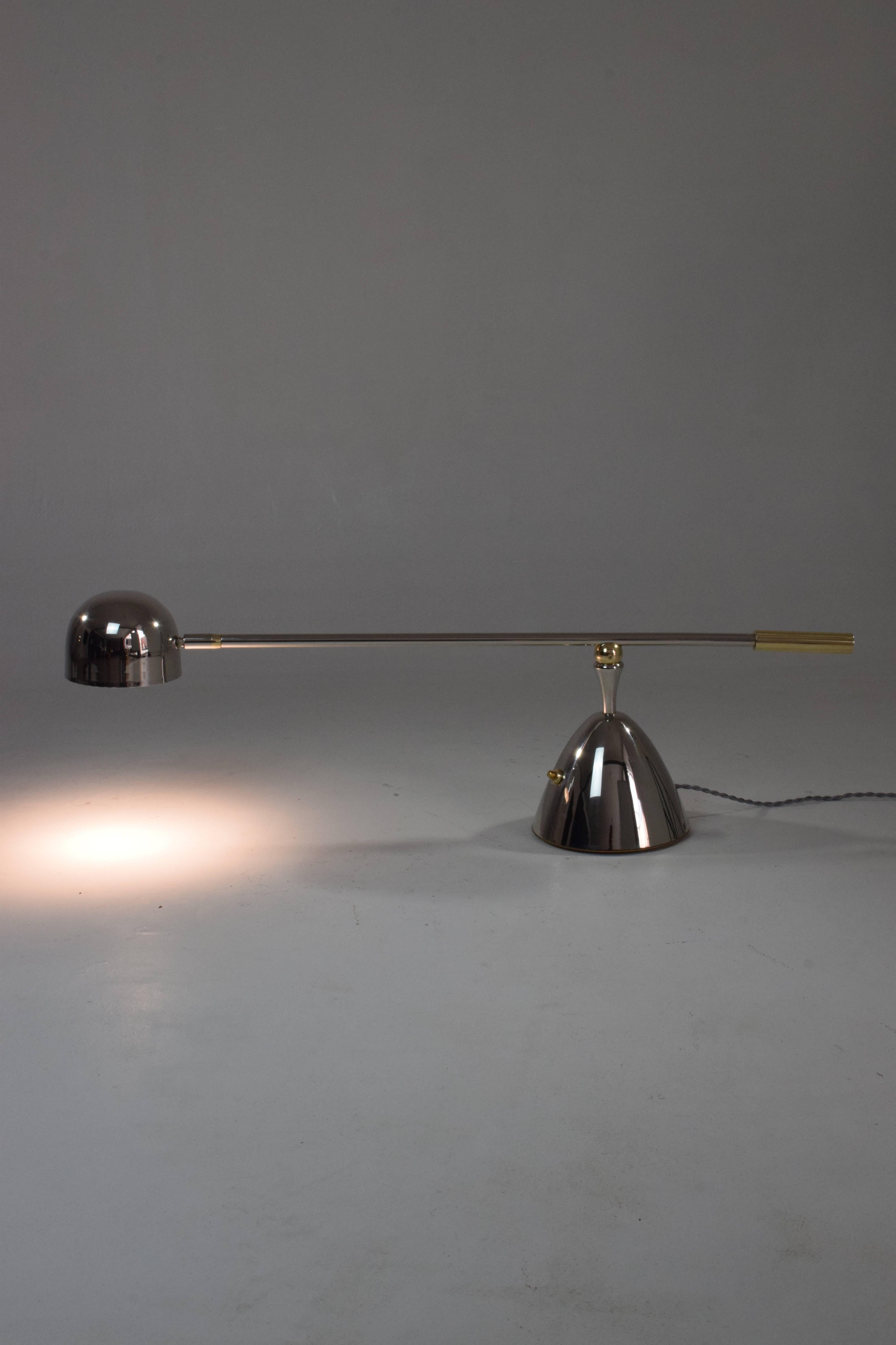 Contemporary handcrafted desk or accent lamp composed of a solid polish brass structure and designed with an adjustable stem and a rotatable shade. This piece rotates around two axis: the shade and the base. The Continuum-I Model II is part of the